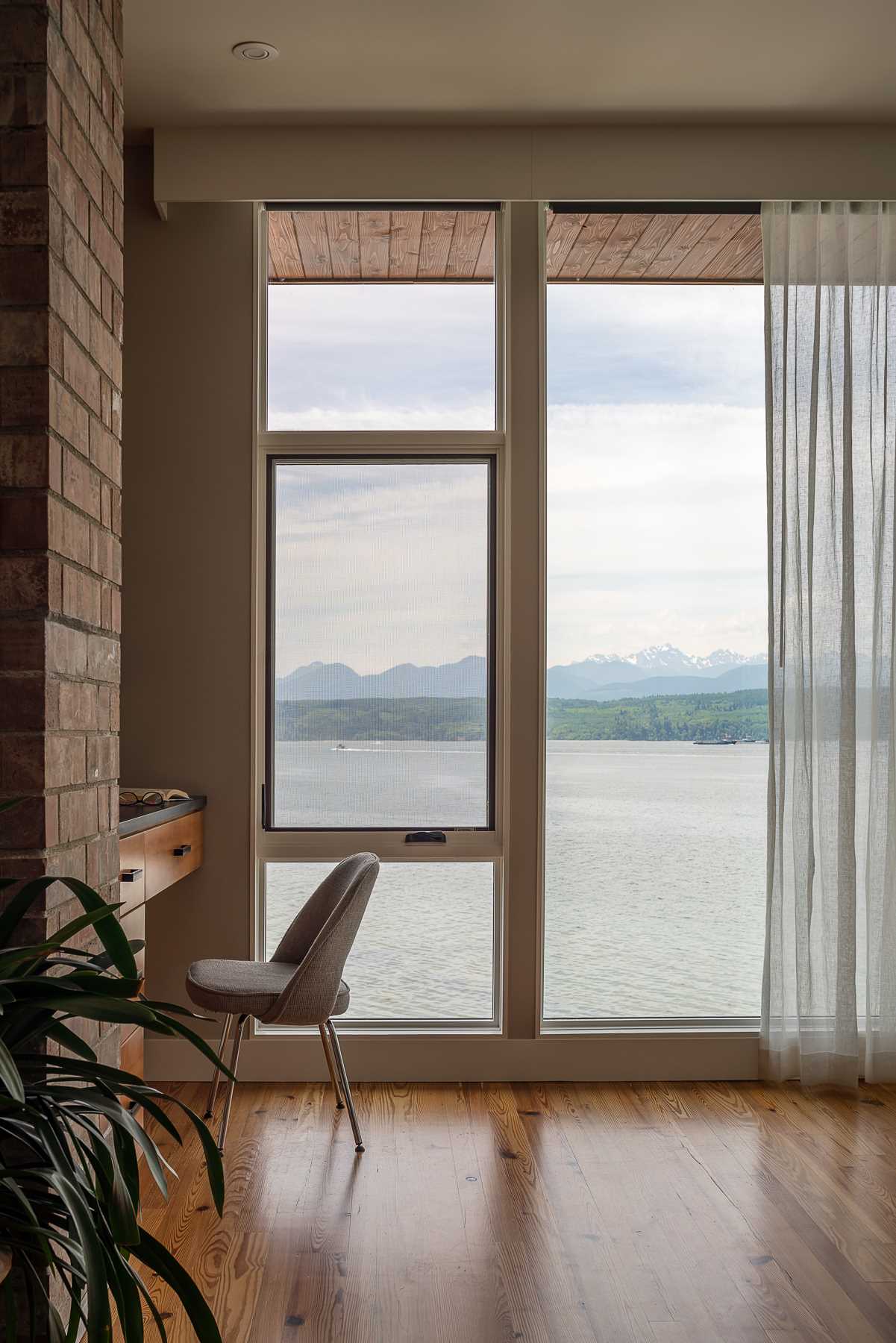 A contemporary beach house interior with reclaimed wood flooring and picture windows.