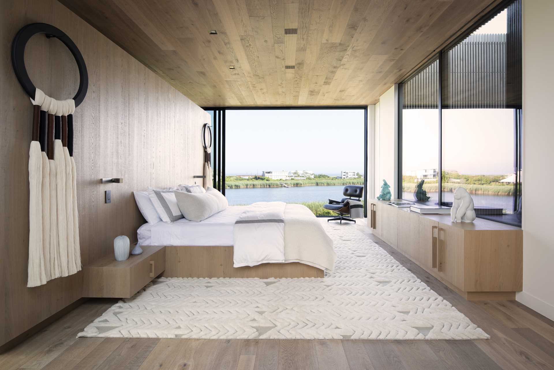 În acest dormitor modern, o paletă care include lemn și crem permite priveliștii să devină punctul focal și, în același timp, creează o atmosferă calmă.