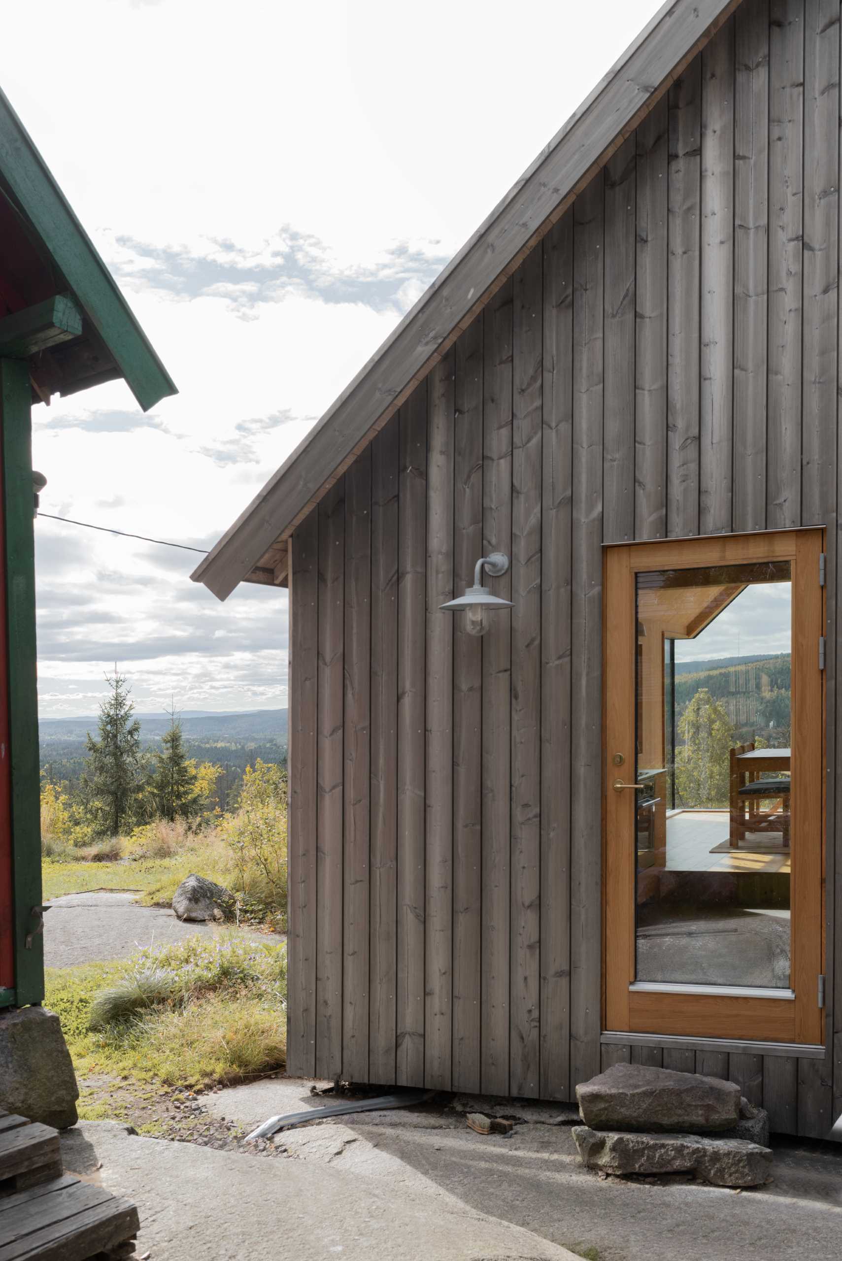 The wood-framed glass door of a contemporary cabin.