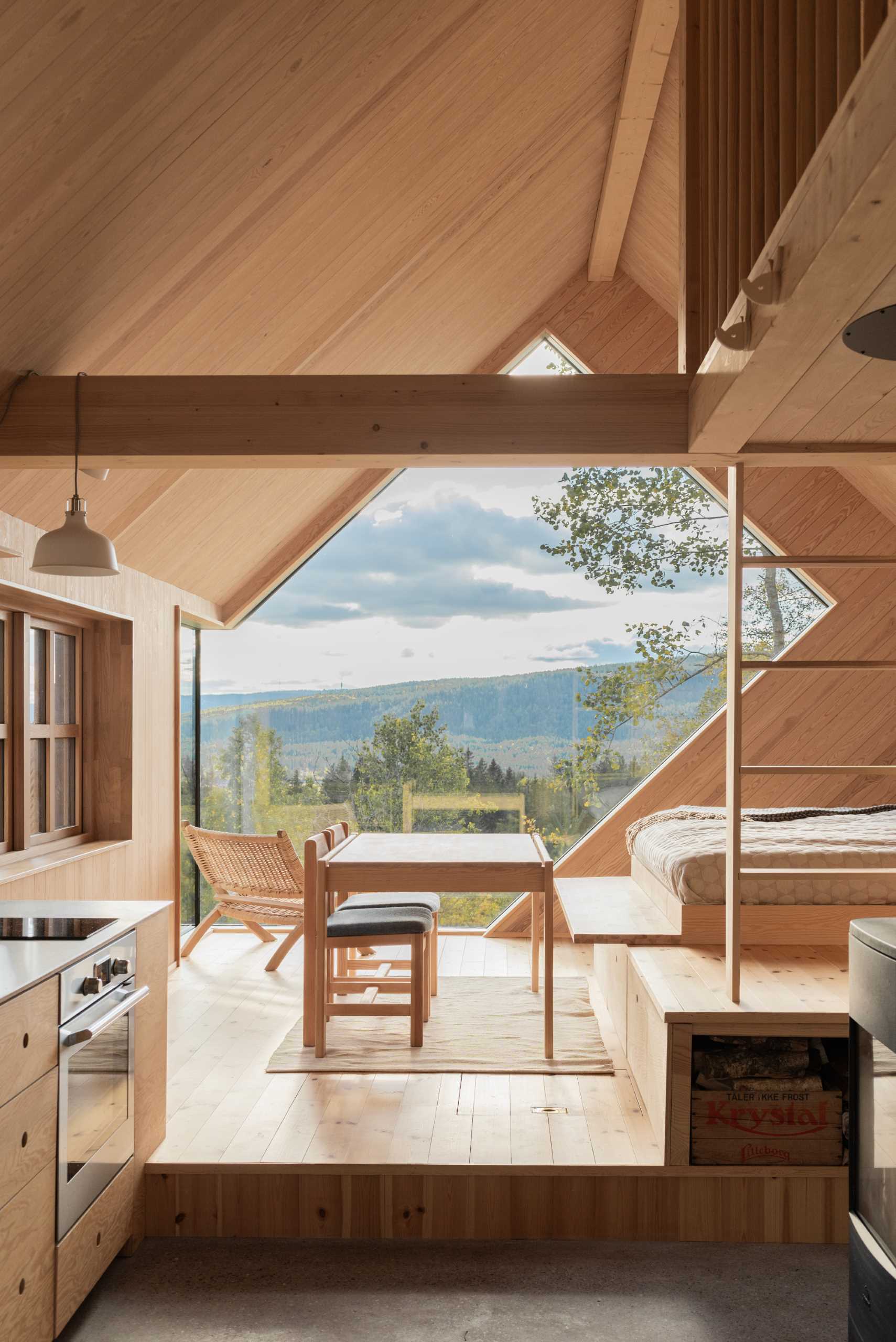 A contemporary cabin designed to include a uniquely shaped window that perfectly frames the sunset.