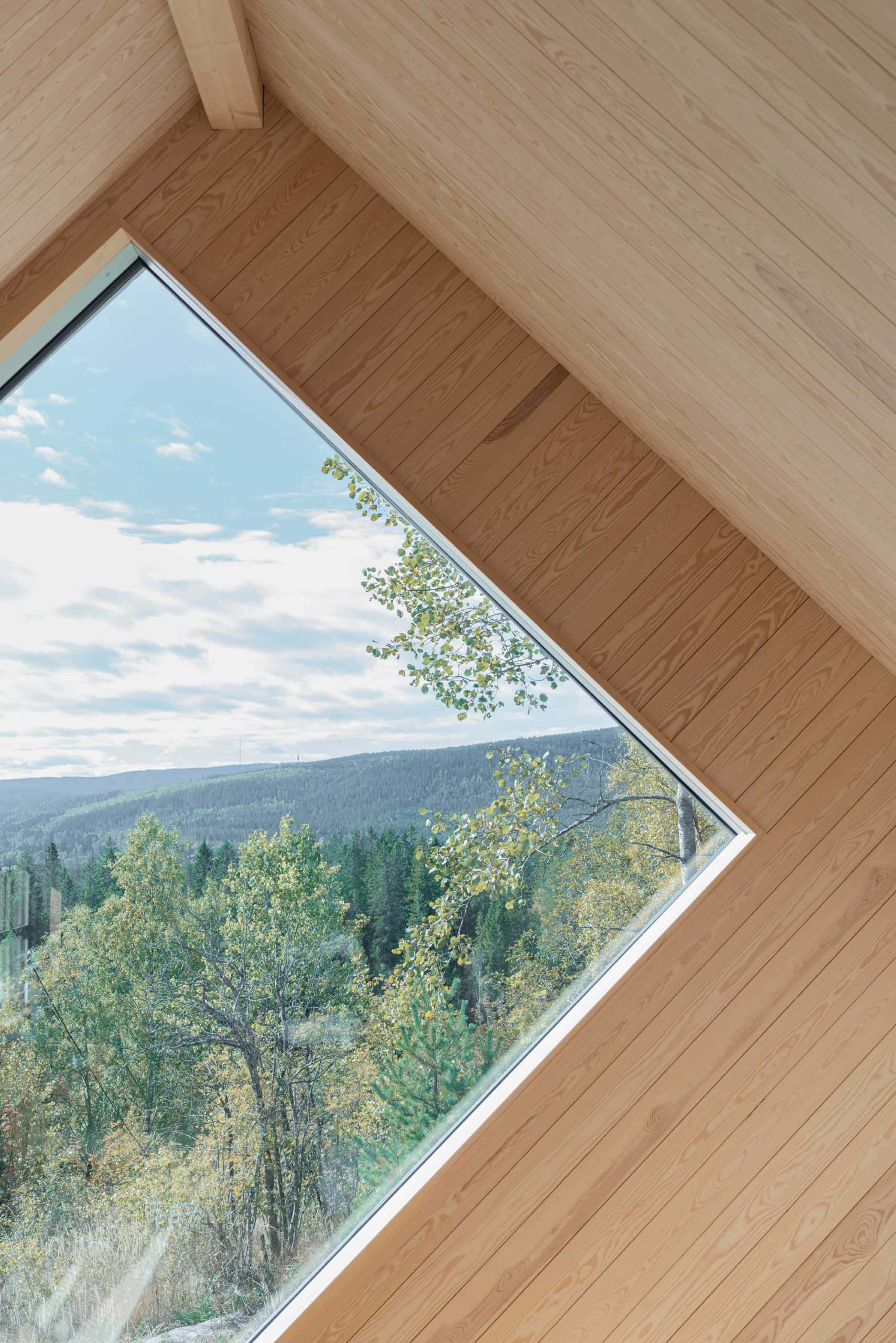 A contemporary cabin designed to include a uniquely shaped window that perfectly frames the sunset.