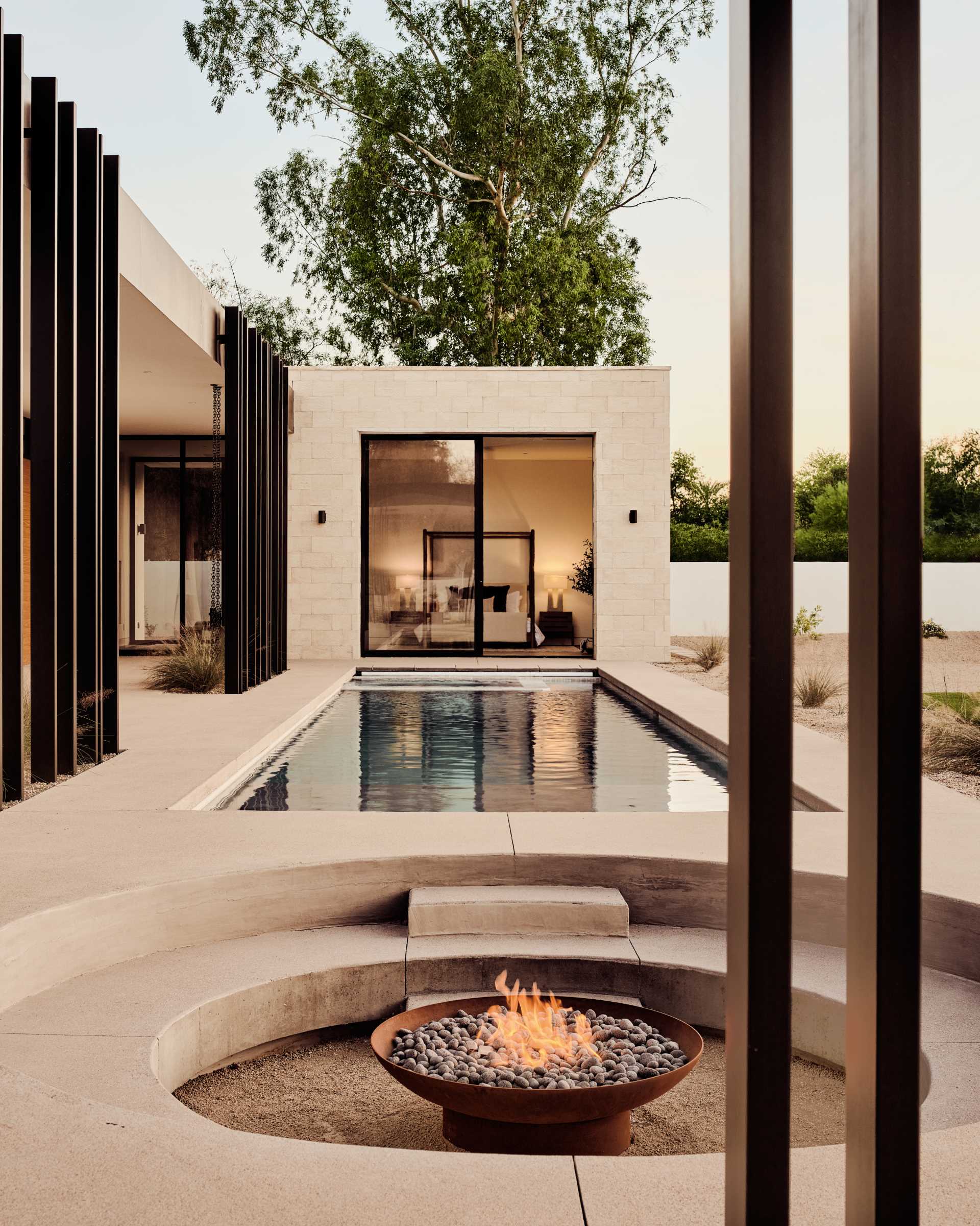Between the pool and covered patio is a circular sunken fire pit that provides an intimate gathering space.
