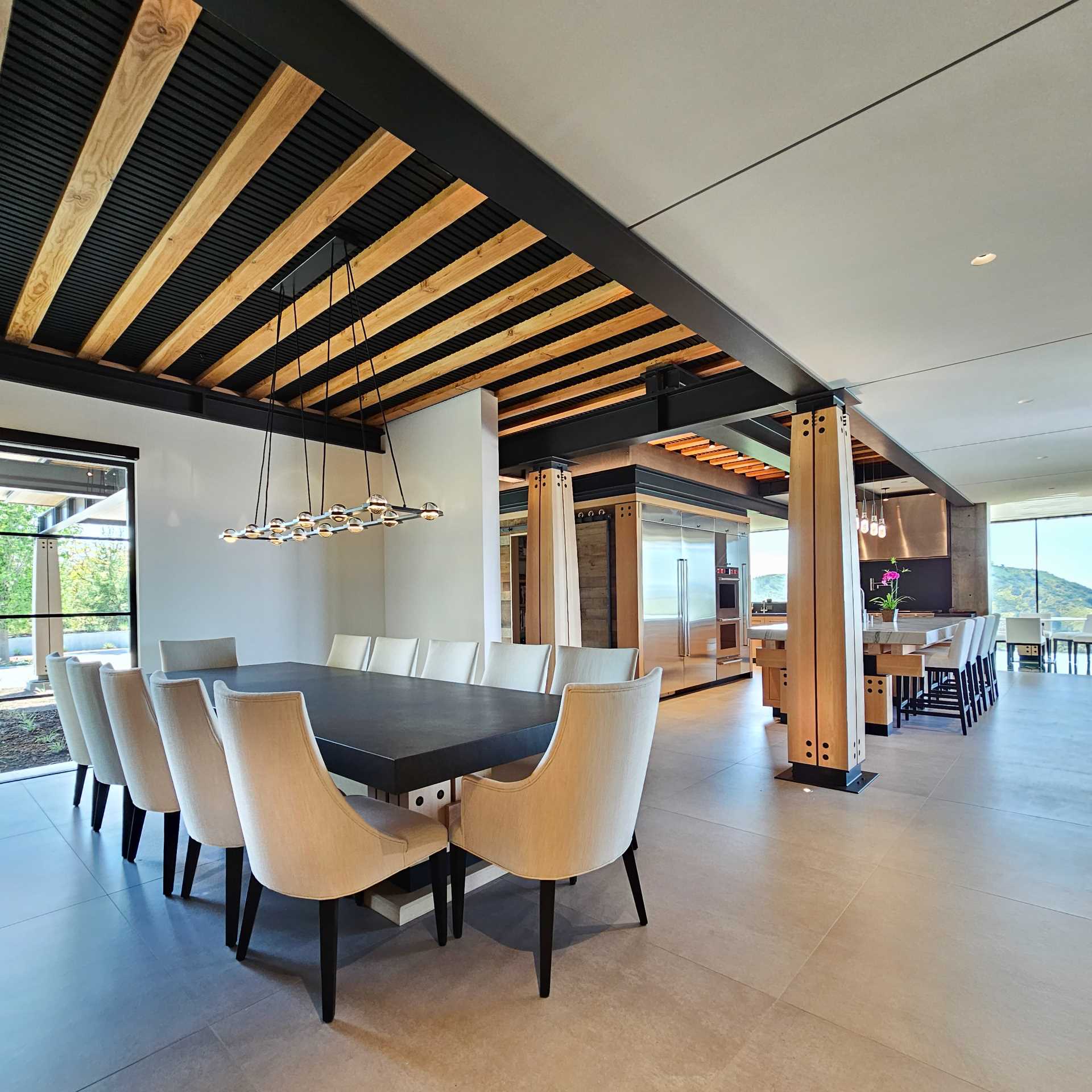 The dining room features a large table with a wood base that matches the nearby columns.