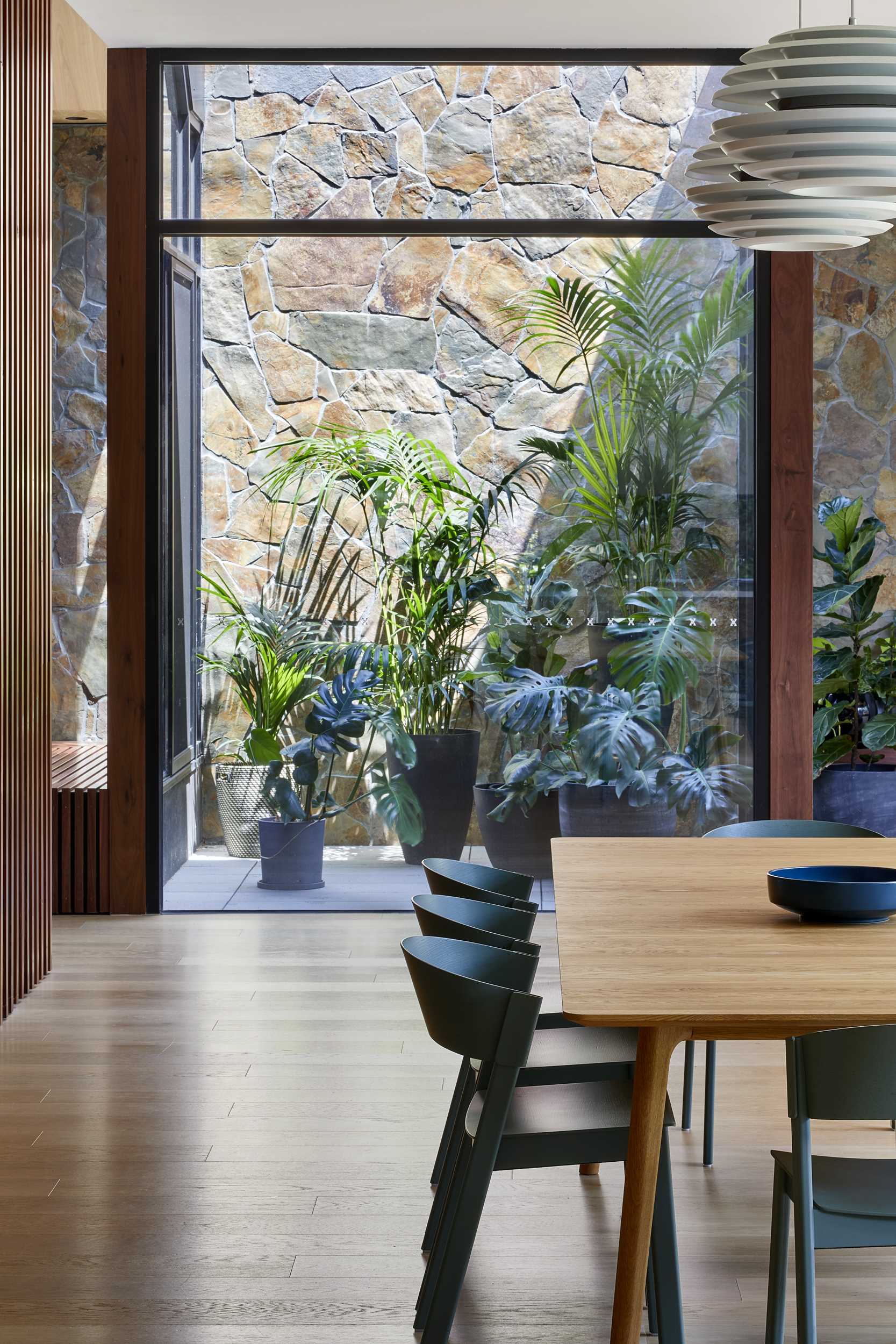 This modern dining room separates the living room from the kitchen, with two pendant lights defining the location of the dining table and chairs.