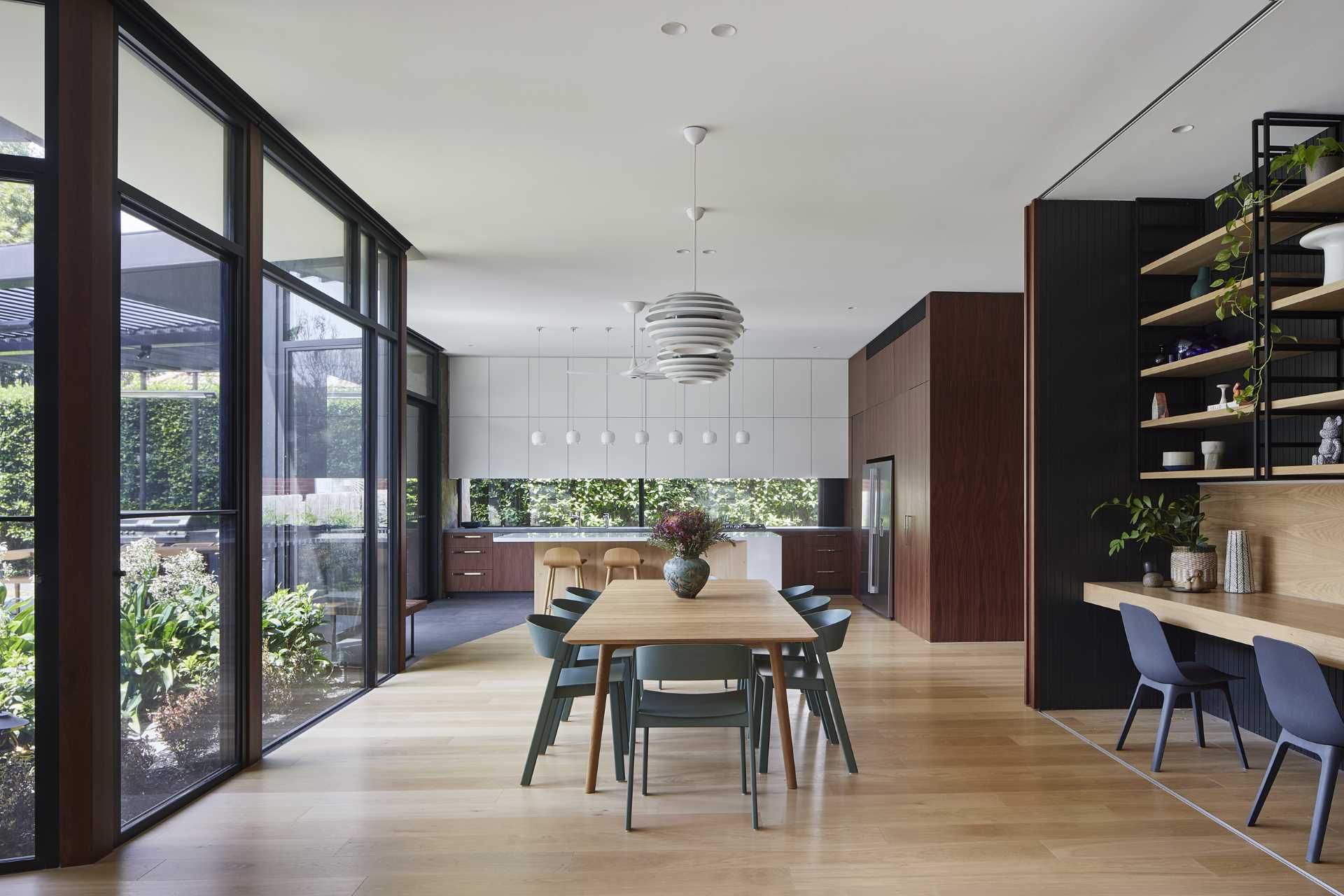 This modern dining room separates the living room from the kitchen, with two pendant lights defining the location of the dining table and chairs.