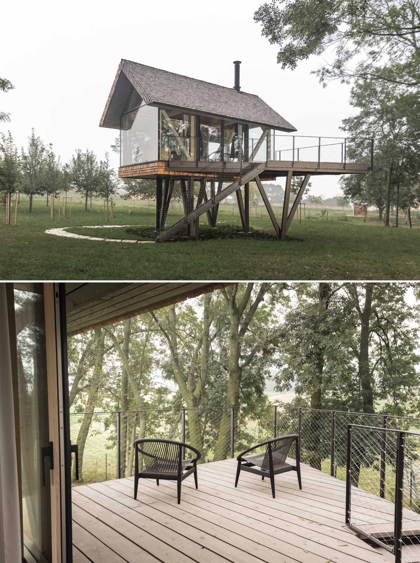 A modern elevated cabin with glass walls, a bed, a bar, and a fireplace.