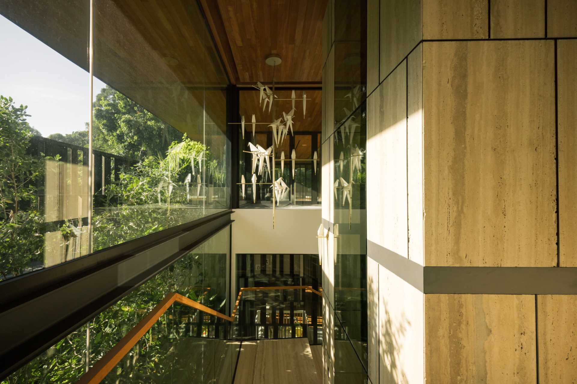 A modern house with a wall of windows that runs alongside the stairs.