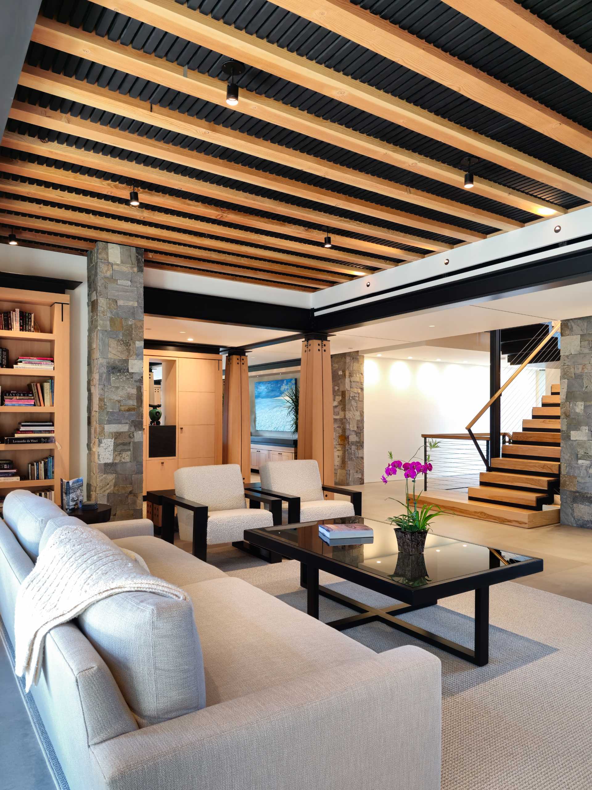 În interiorul acestei locuințe, ca și în zona de relaxare, elementele structurale sunt ușor de văzut, cu suporturi din lemn expuse contrastând cu grinzile de oțel negru.