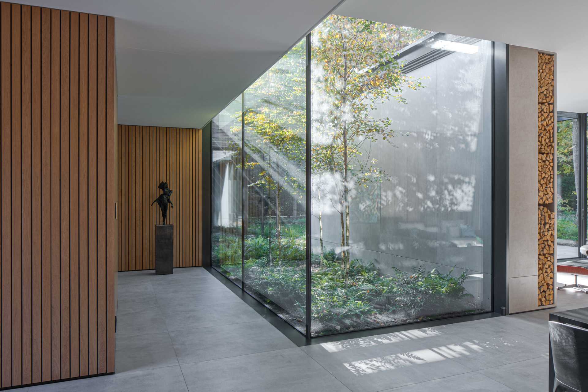 Large floor-to-ceiling windows feature throughout this home, while black window frames create a contrasting element that complements the furnishings.