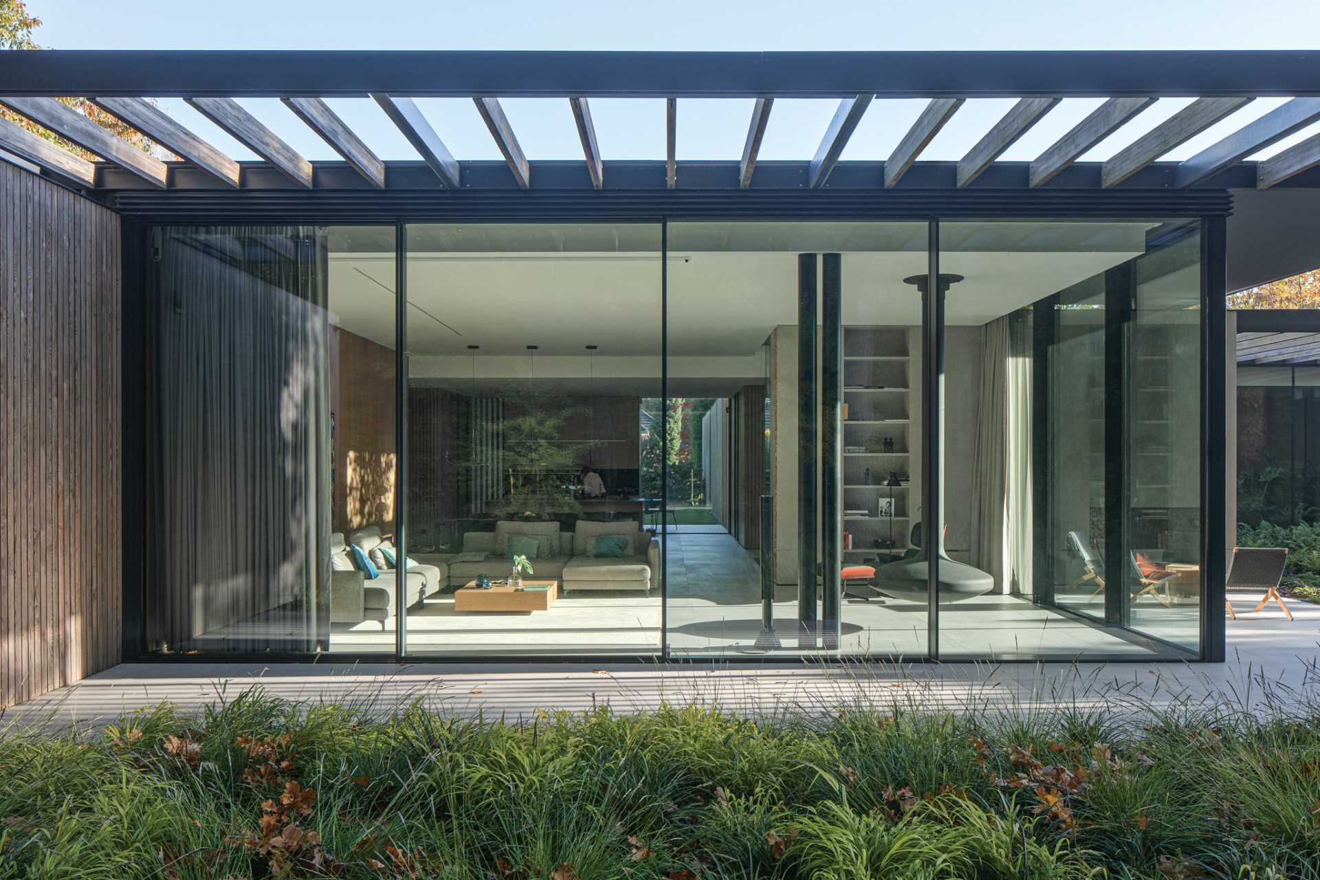 On the side of this home that faces the forest, where the setting is more intimate, the boundary between interior and exterior is blurred with glass panels.