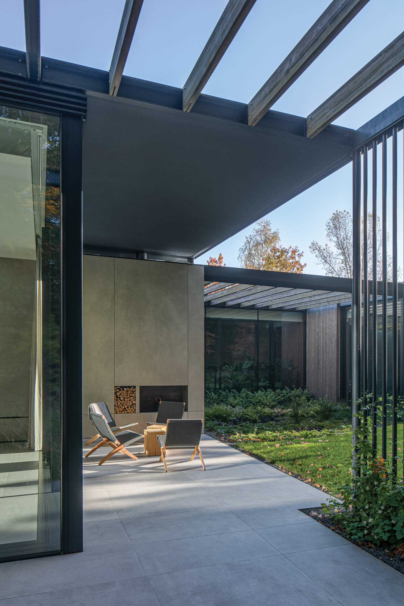 Large-format quartz features on the floor inside and out this modern home, as seen in a patio with an outdoor fireplace that's located off the living room.