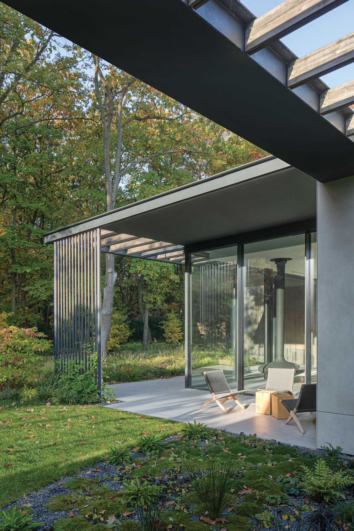 Large-format quartz features on the floor inside and out this modern home, as seen in a patio with an outdoor fireplace that's located off the living room.