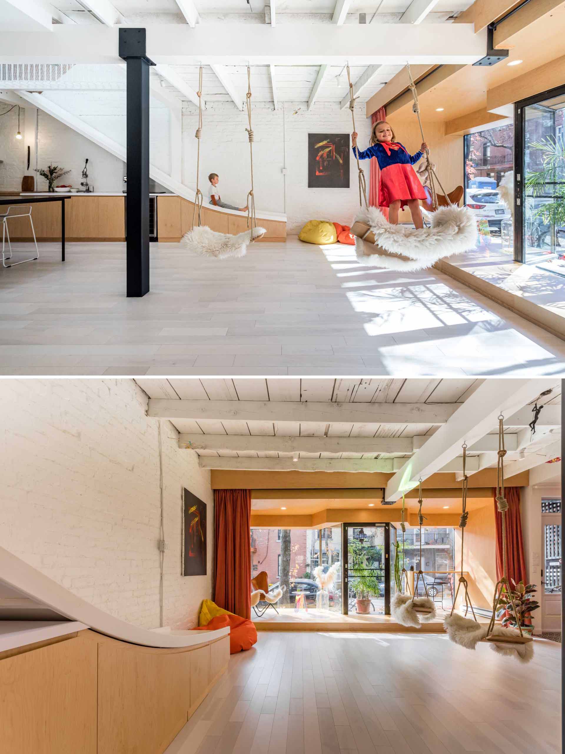 This modern interior includes a pair of swings and a slide that connects the two floors of the home.