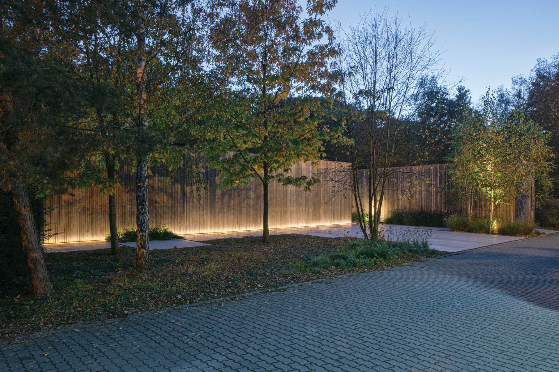 Exterior lighting added to the facade of this modern home lights up the vertical wood and showcases the lines of the home.