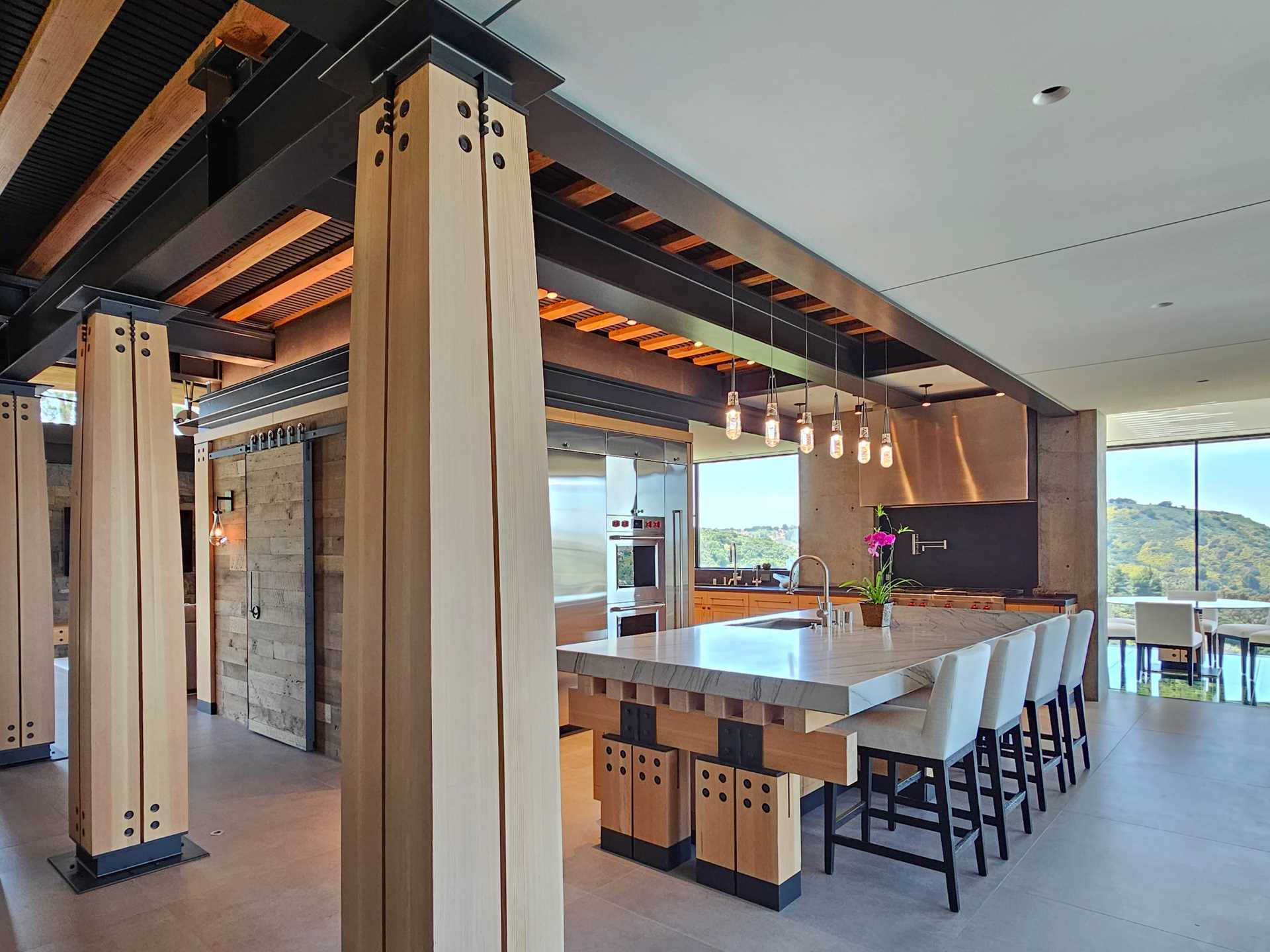 In the heart of the home, the kitchen bridges modern design and craftsman style warmth, with heavy Douglas Fir timber cabinetry.