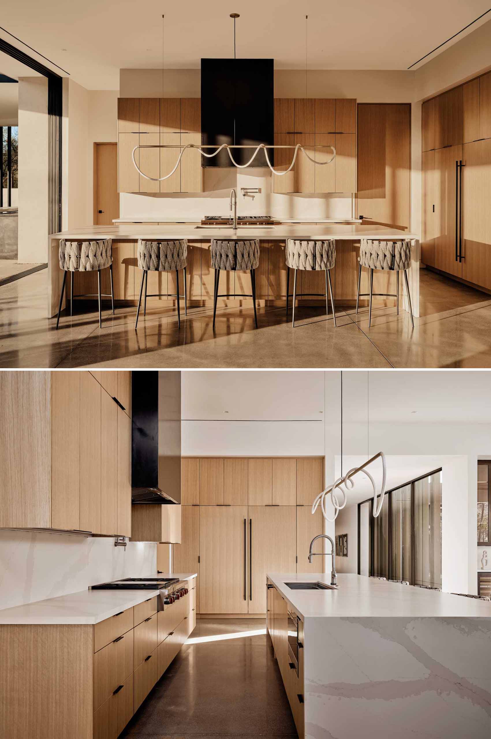 In this kitchen, a sculptural light hangs above the island, while tall wood cabinetry provides plenty of storage.
