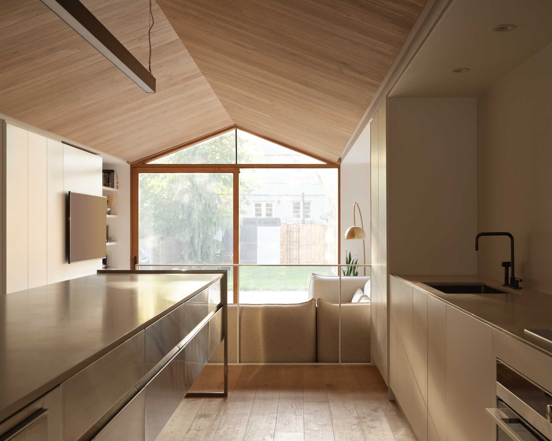 A few steps up from the living room is the kitchen, which includes a long island, with cabinets lining the wall.