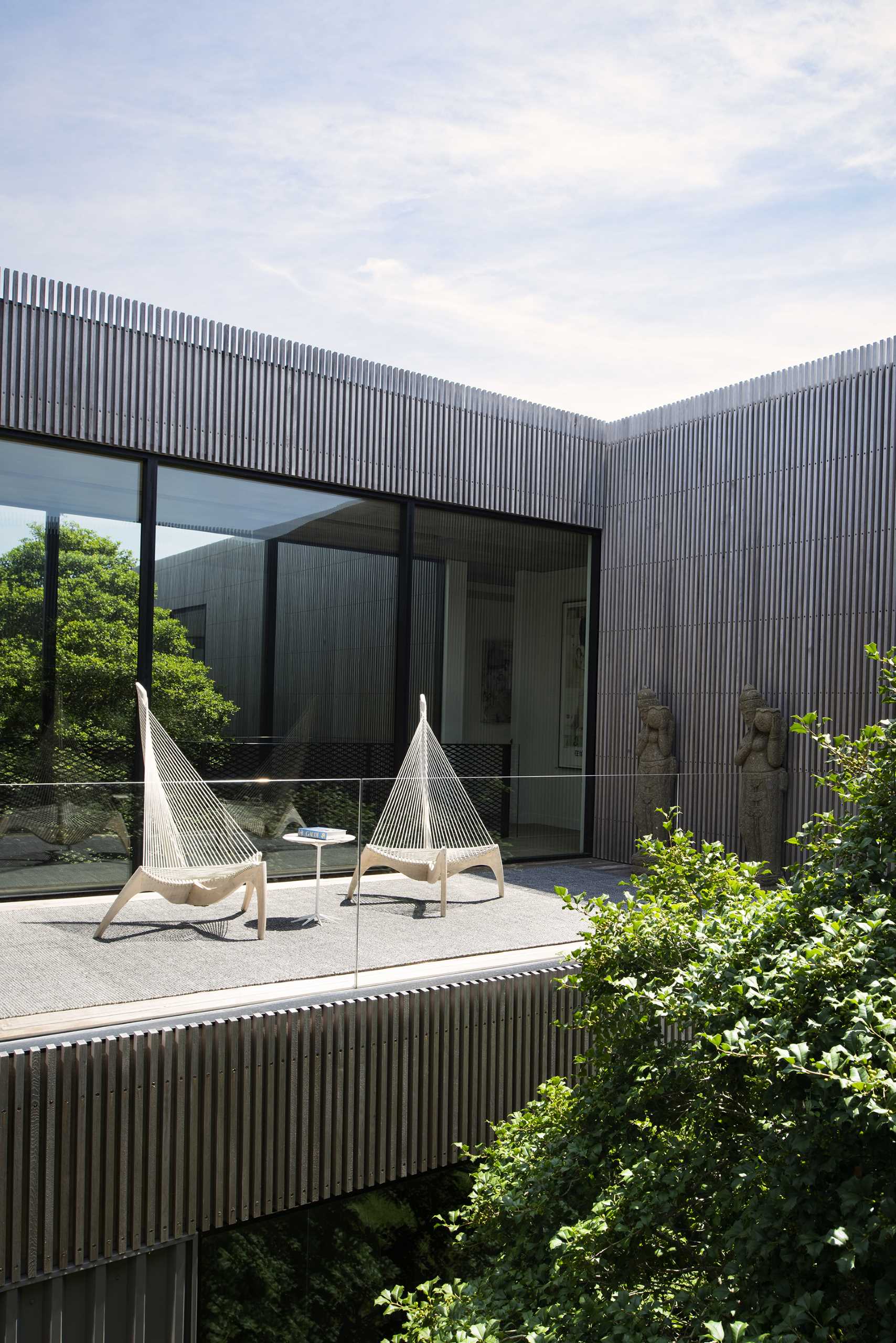 A modern home with a private patio furnished with two sculptural chairs.