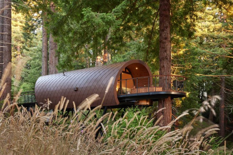 A Tube Shaped Treehouse Wrapped In Diamond-Shaped Metal Tiles