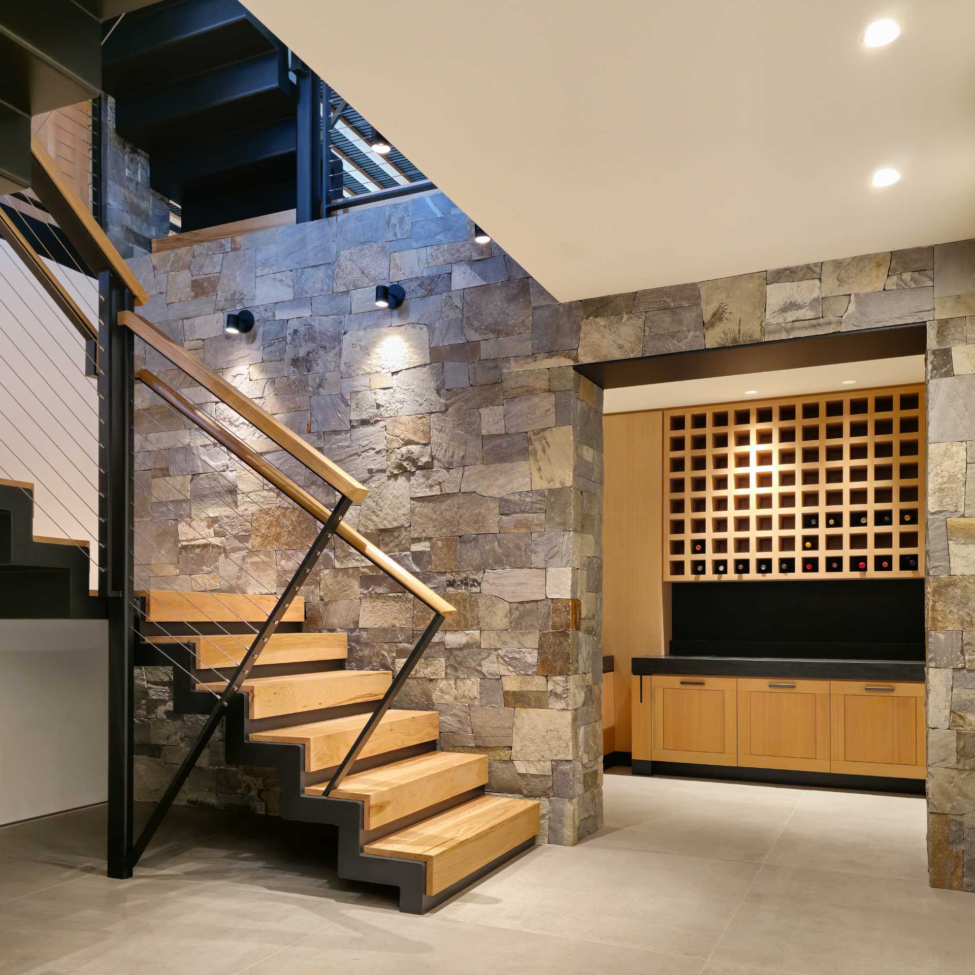 O casă modernă, cu scări din oțel și lemn și un suport de vin încorporat.