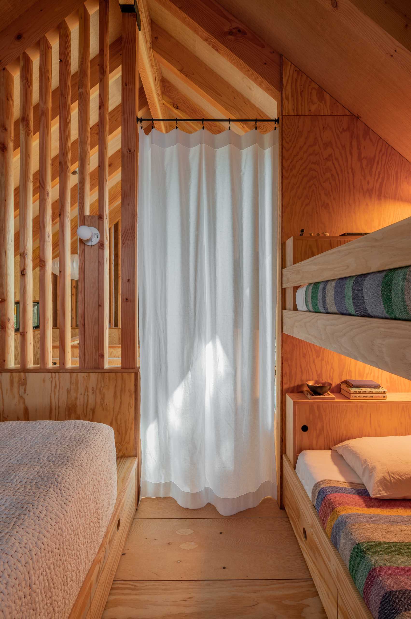The bedrooms in this cabin are located on either side of the lounge area, with both bunk beds and regular beds. Curtains can be drawn to provide privacy when needed.