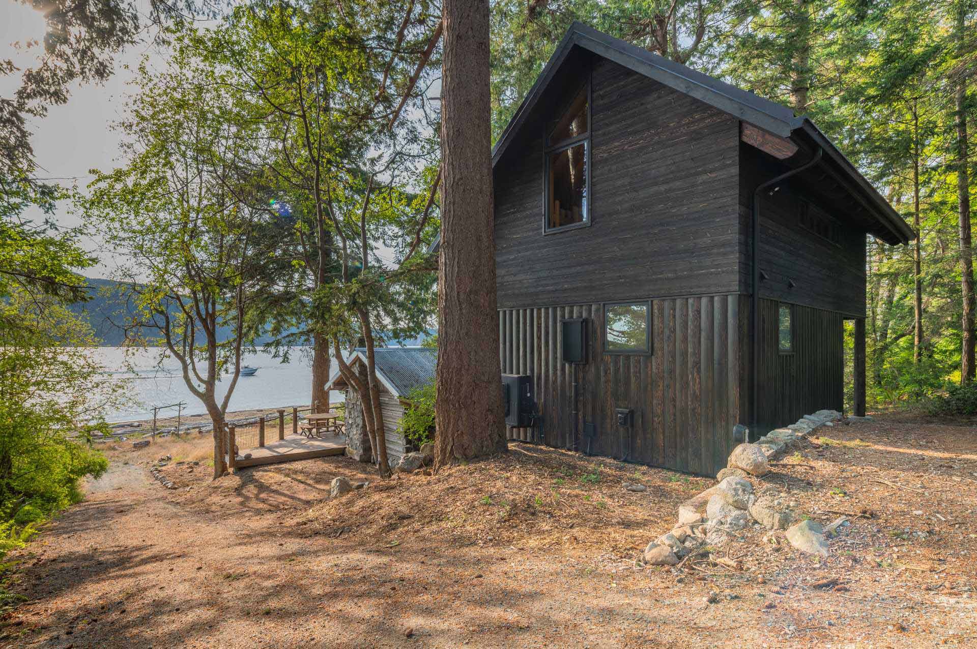 The exterior of the cabin features tongue and groove rough-sawn Western Red Cedar cladding, while the lower section has Disdero Cabin Log Siding. Both of which have been stained black.
