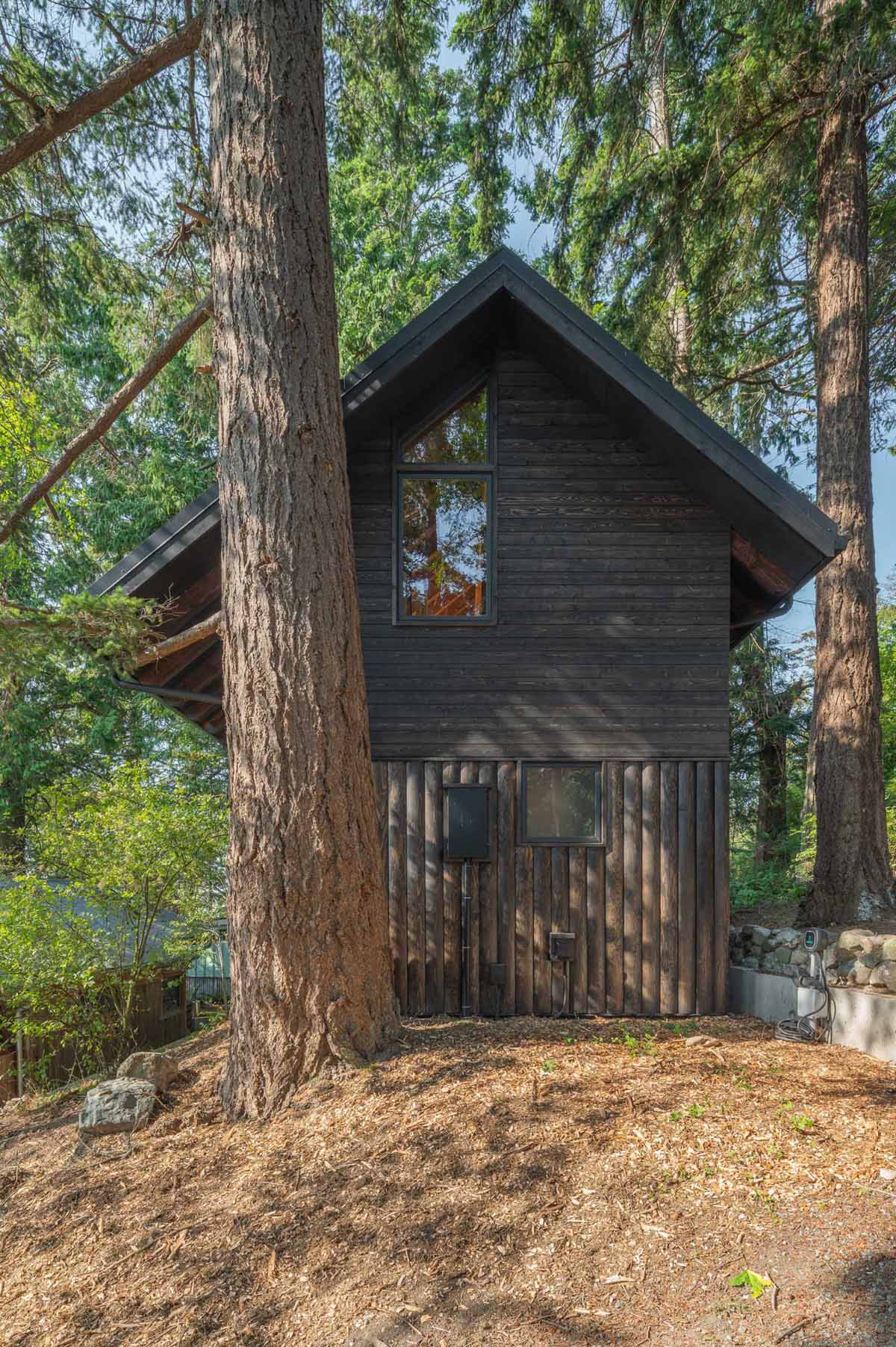 The exterior of the cabin features tongue and groove rough-sawn Western Red Cedar cladding, while the lower section has Disdero Cabin Log Siding. Both of which have been stained black.