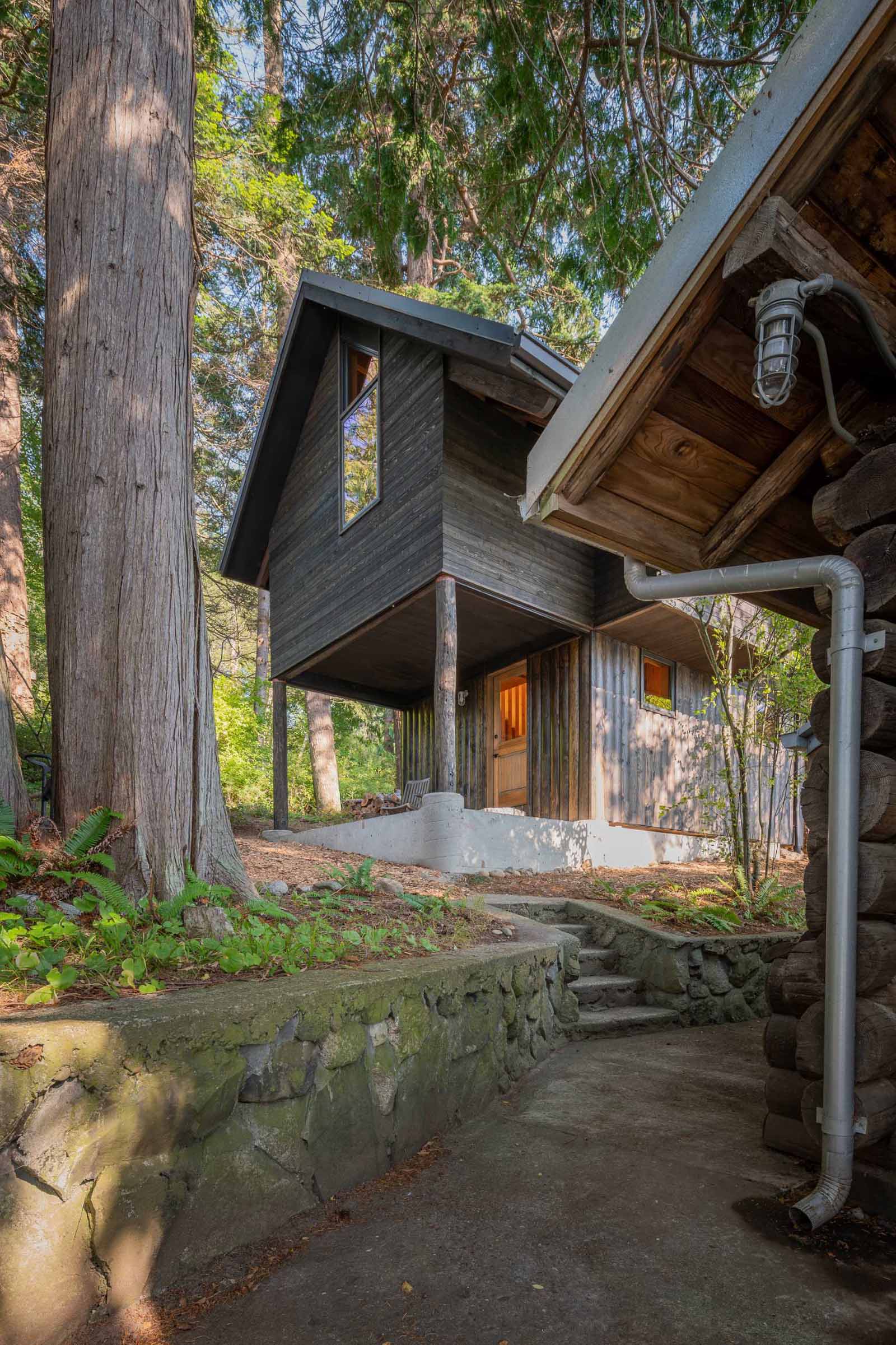 The exterior of the cabin features tongue and groove rough-sawn Western Red Cedar cladding, while the lower section has Disdero Cabin Log Siding. Both of which have been stained black.