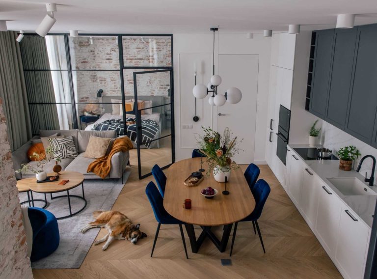 A Glass Wall Separates A Bedroom From The Living Spaces In This Apartment