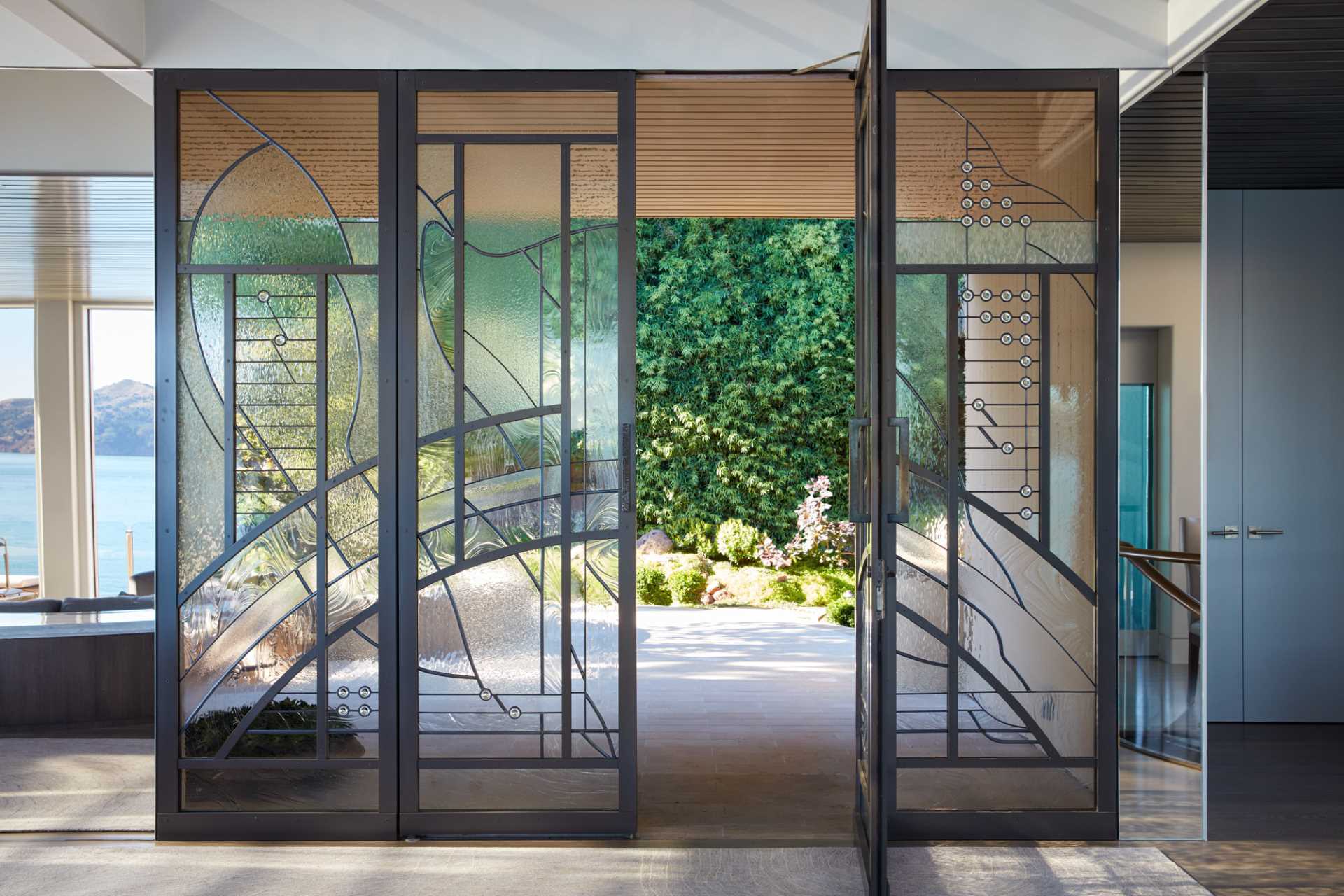 A black-framed artistic glass front door welcomes visitors to the home.