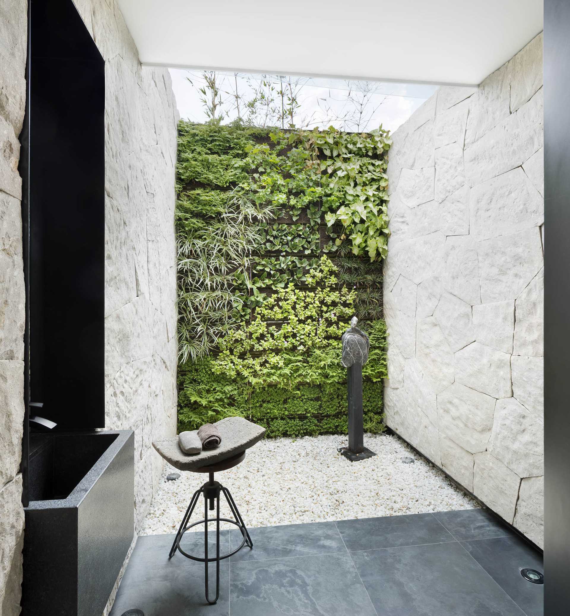 A modern outdoor bathroom with a green wall.