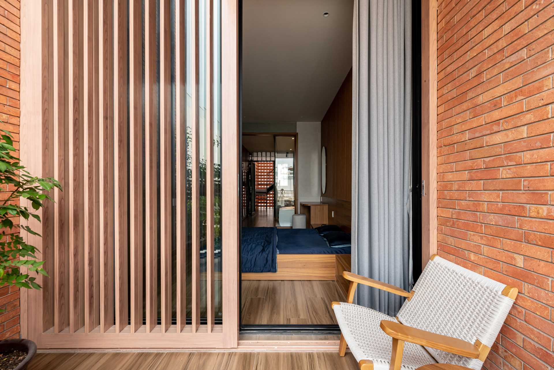 A modern bedroom with a glass-enclosed bathroom and a balcony.