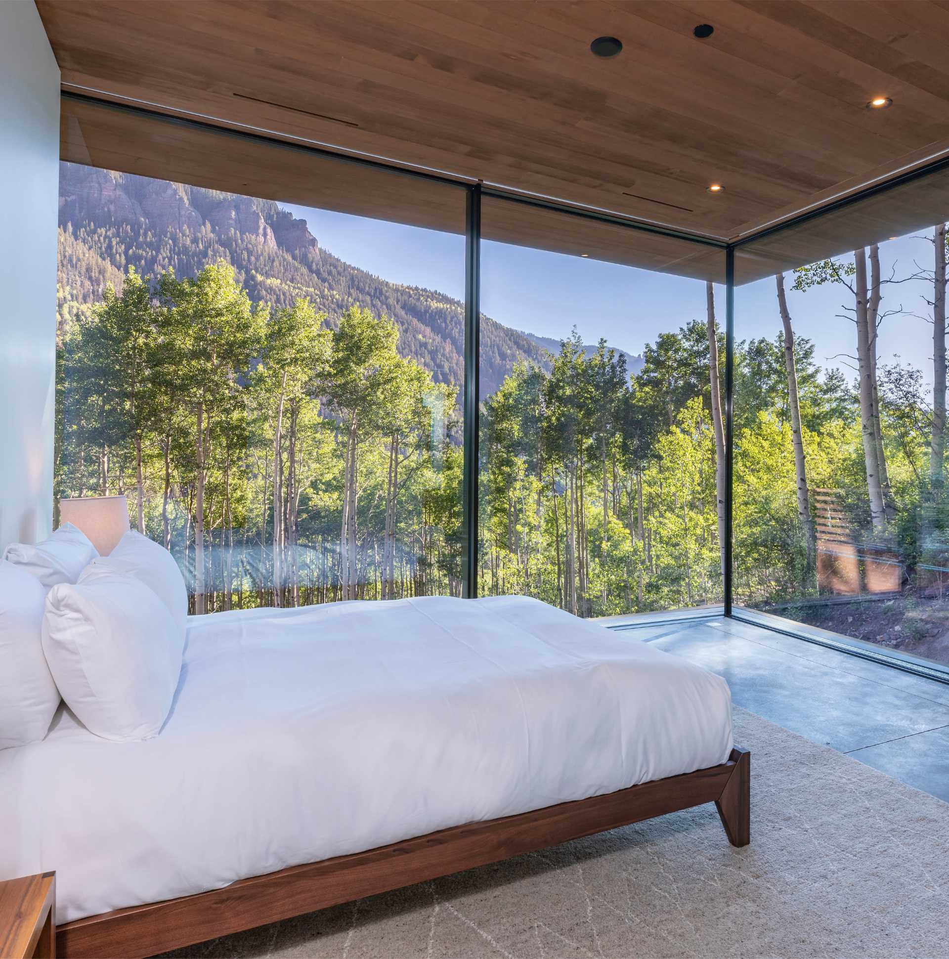 A modern bedroom with glass walls.