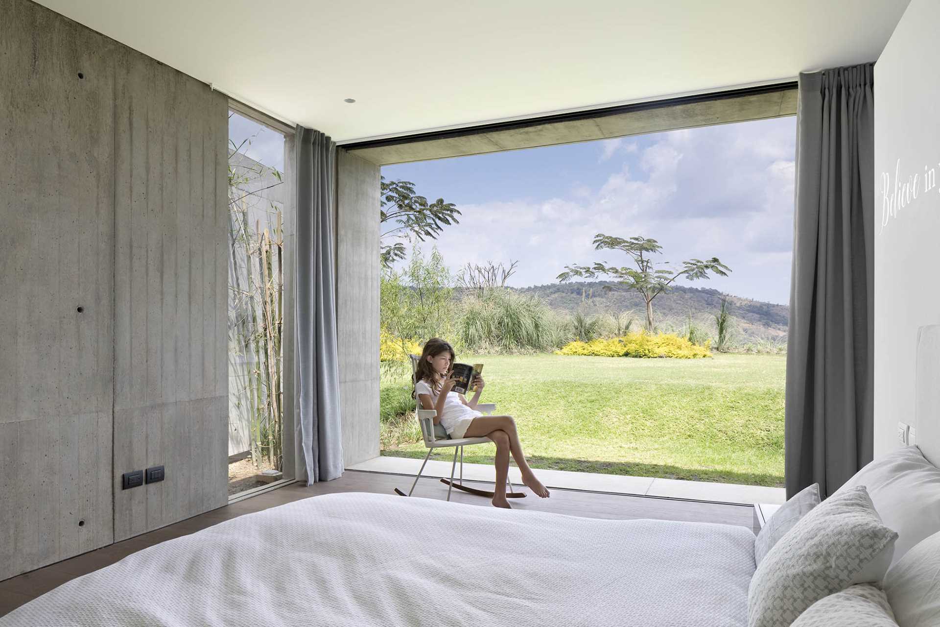 A modern bedroom with sliding doors that open to the outdoors.