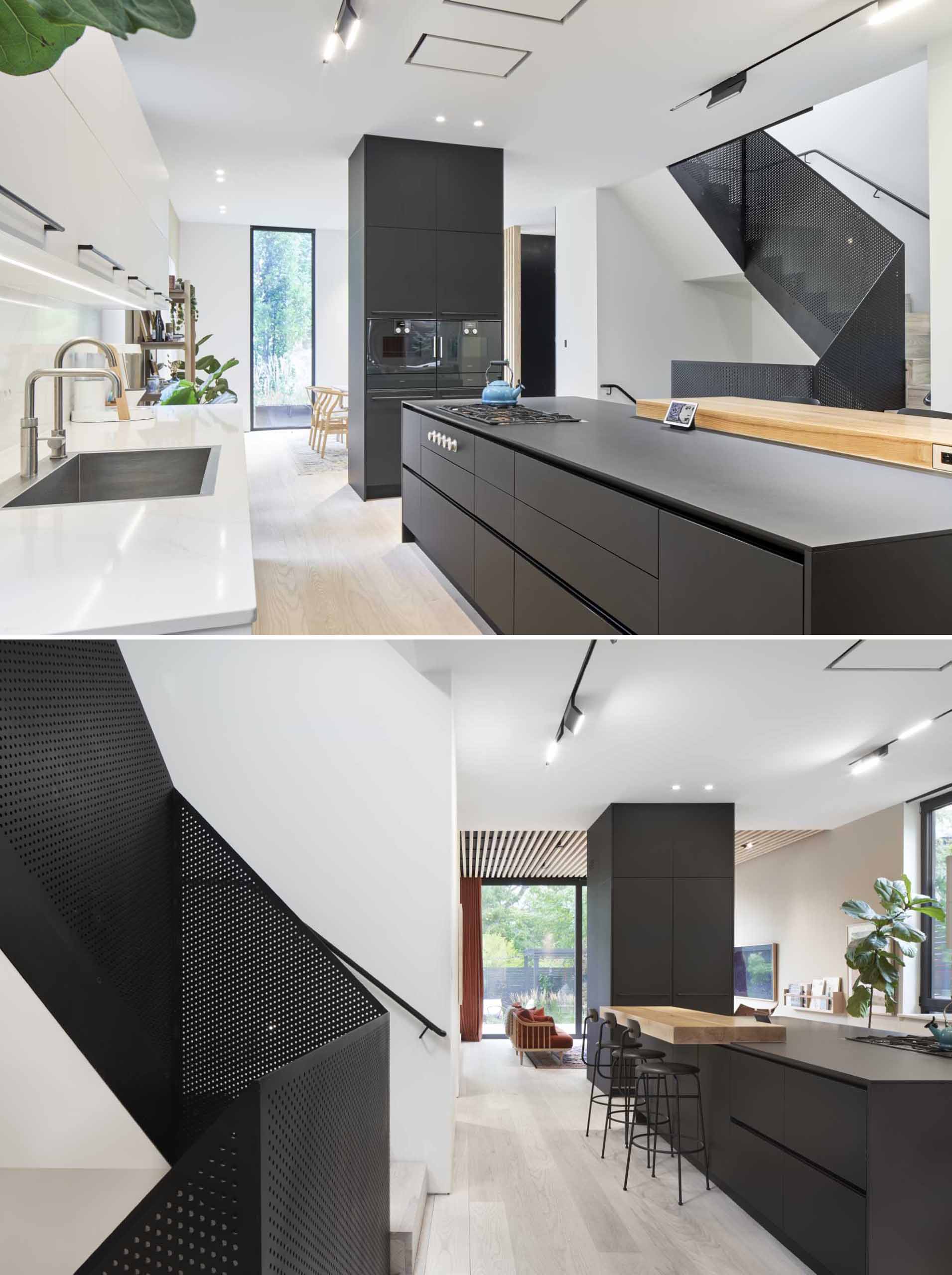 The kitchen, with its black and white cabinetry, is positioned between the dining room and the living room.