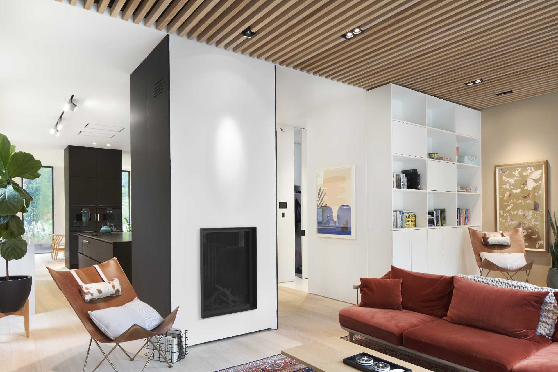 The living room is located at the rear of the home and is defined by the wood slat accent ceiling, while a large sliding door opens to provide access to the backyard.