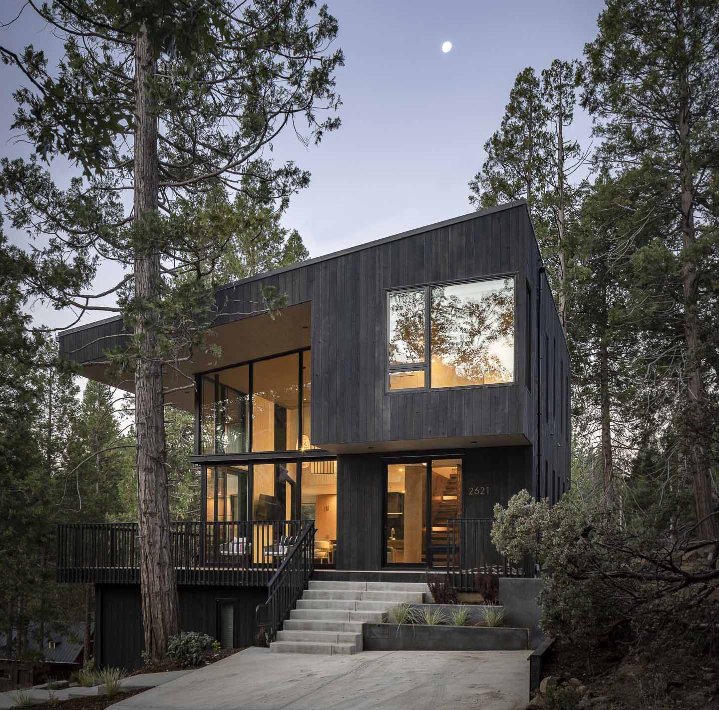 Dark vertical wood siding was chosen as the primary exterior cladding to “camouflage” this home and allow it to blend into the environment as much as possible.