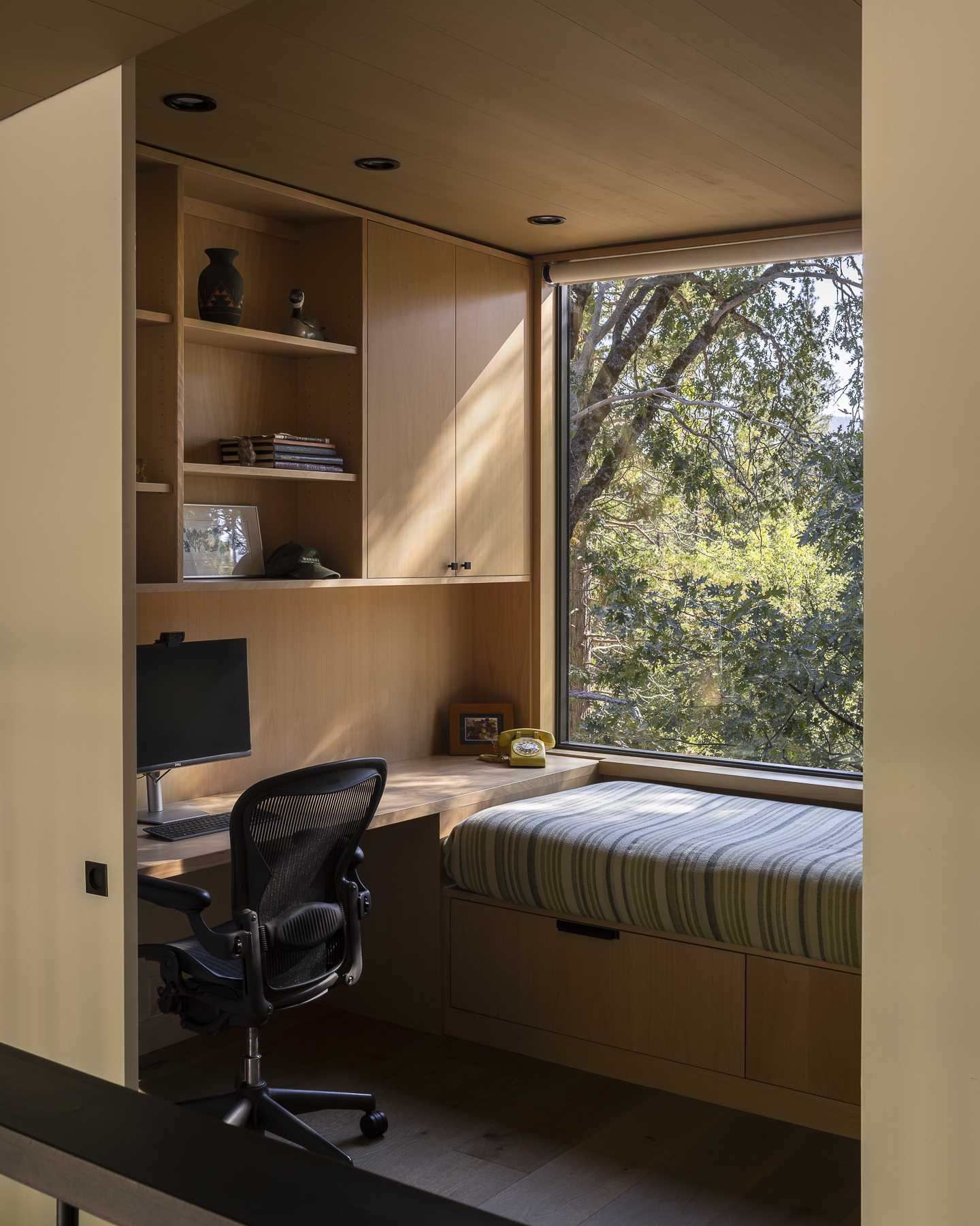 A small room with a built-in desk with shelving and cabinetry.