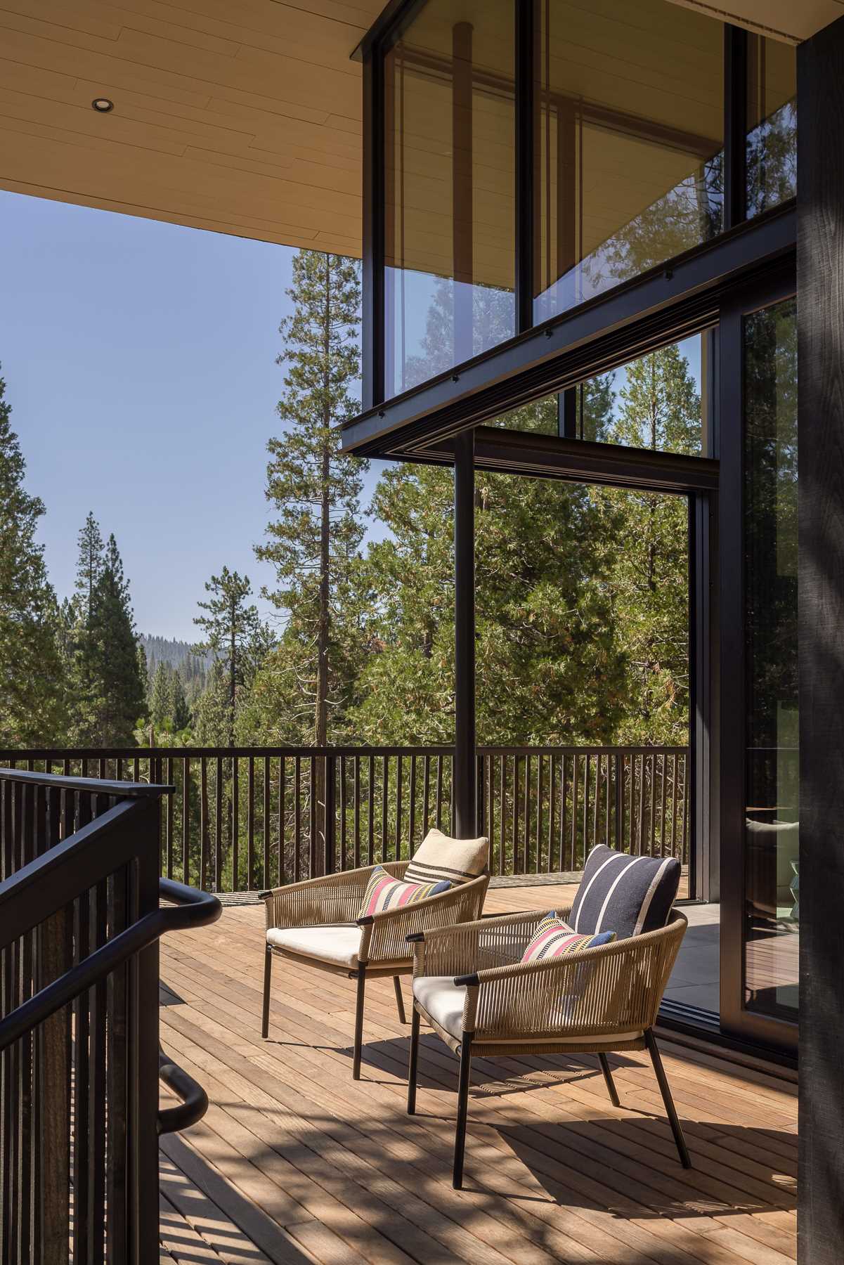 The pickets of the wraparound deck are the same material as the siding, but their spacing makes the siding seem to dissolve into the air, creating a balance between enclosure and openness to views.