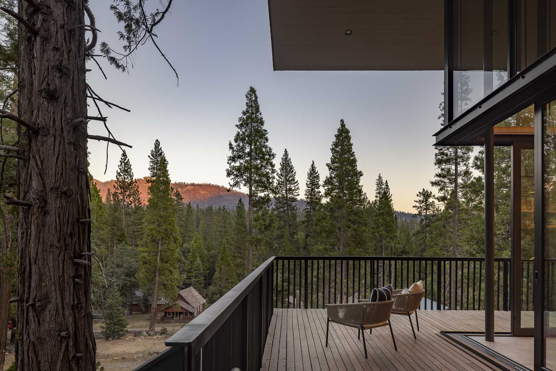 The pickets of the wraparound deck are the same material as the siding, but their spacing makes the siding seem to dissolve into the air, creating a balance between enclosure and openness to views.