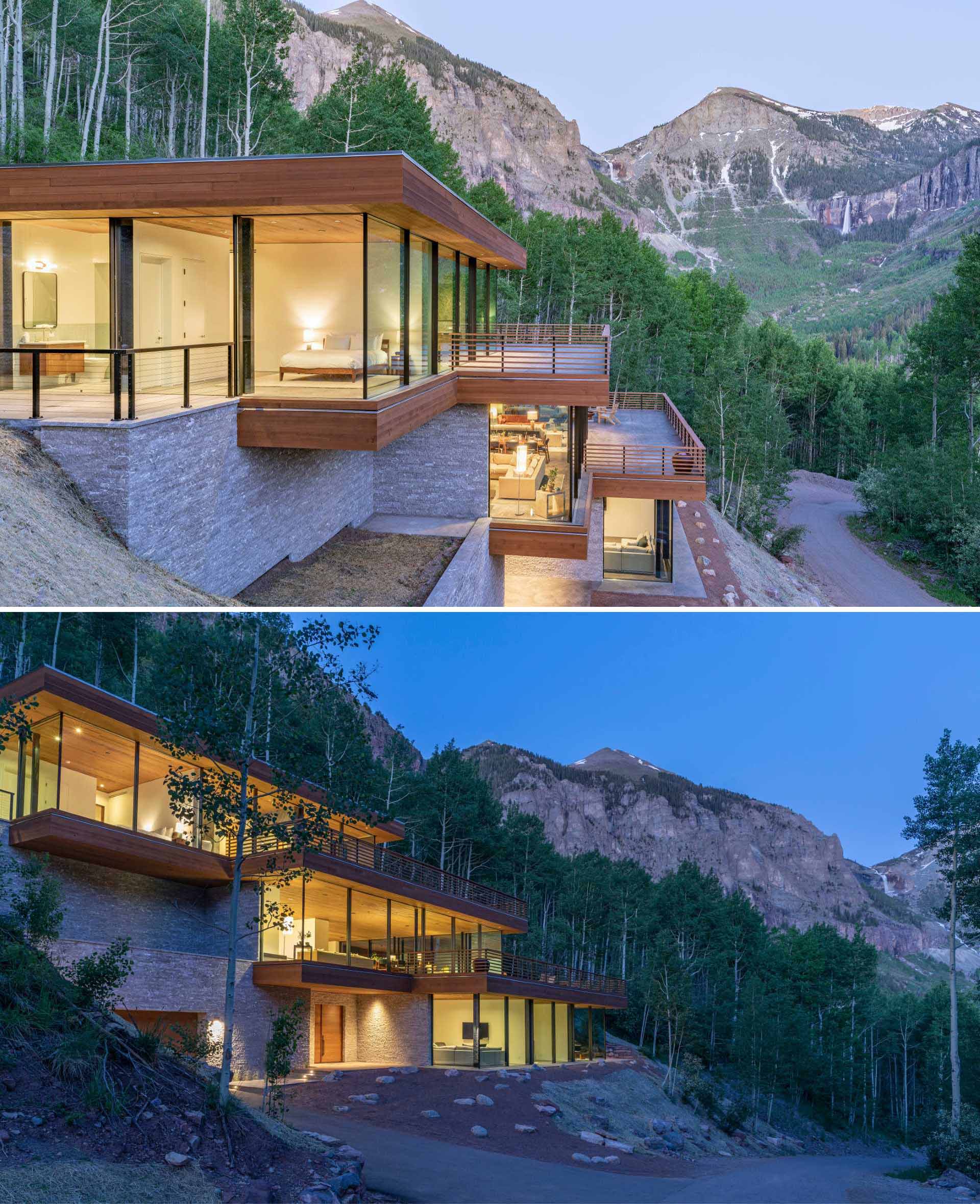 A modern home nestled into the steep cliffs appears as three cantilevered glass boxes.