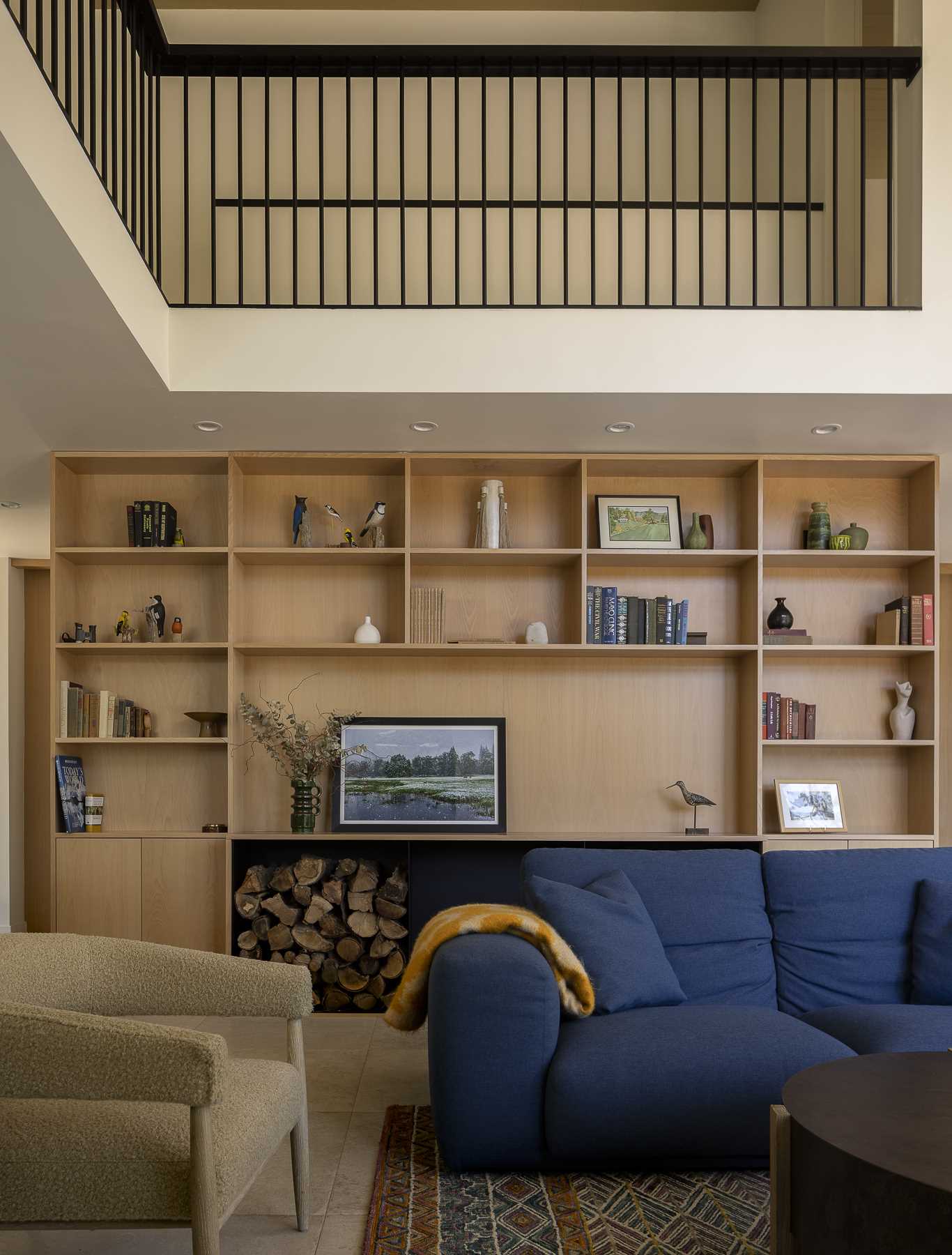 Behind the couch is a wall of custom built-in wood shelving for displaying decor and books.