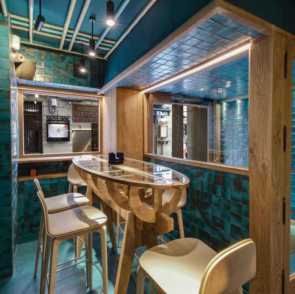 Stepping inside this restaurant, you're immediately surrounded by handmade ceramic tiles, designed specifically for the project as a way of introducing an aquatic effect through its intense turquoise color, its imperfections, and its brightness.