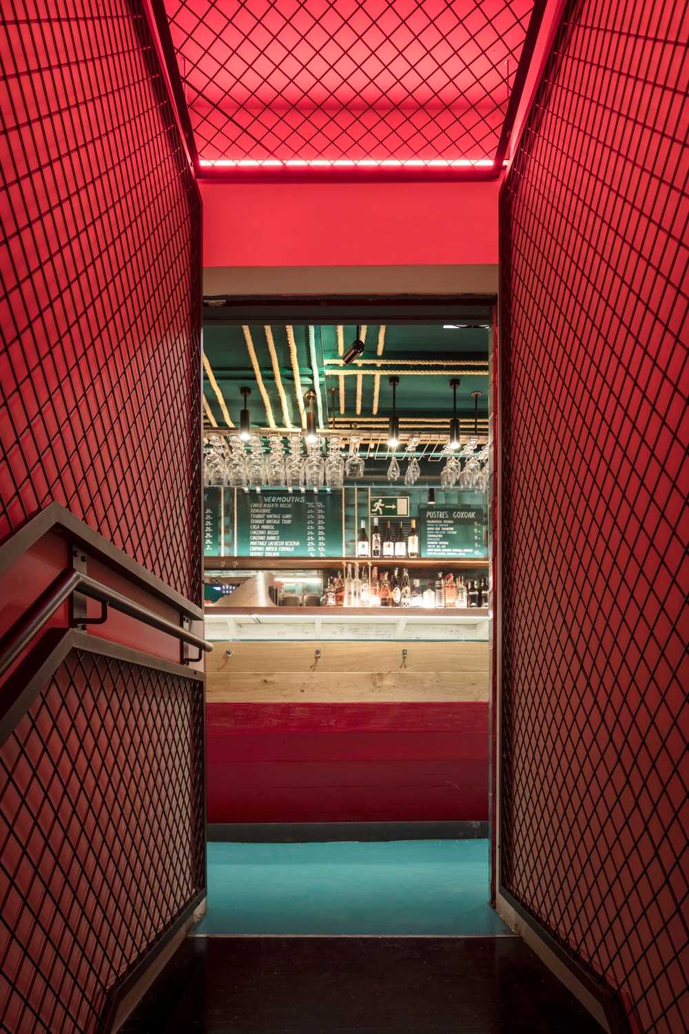 A narrow and mysterious tunnel lined with red light attracts customers to the basement, where a private club is located.