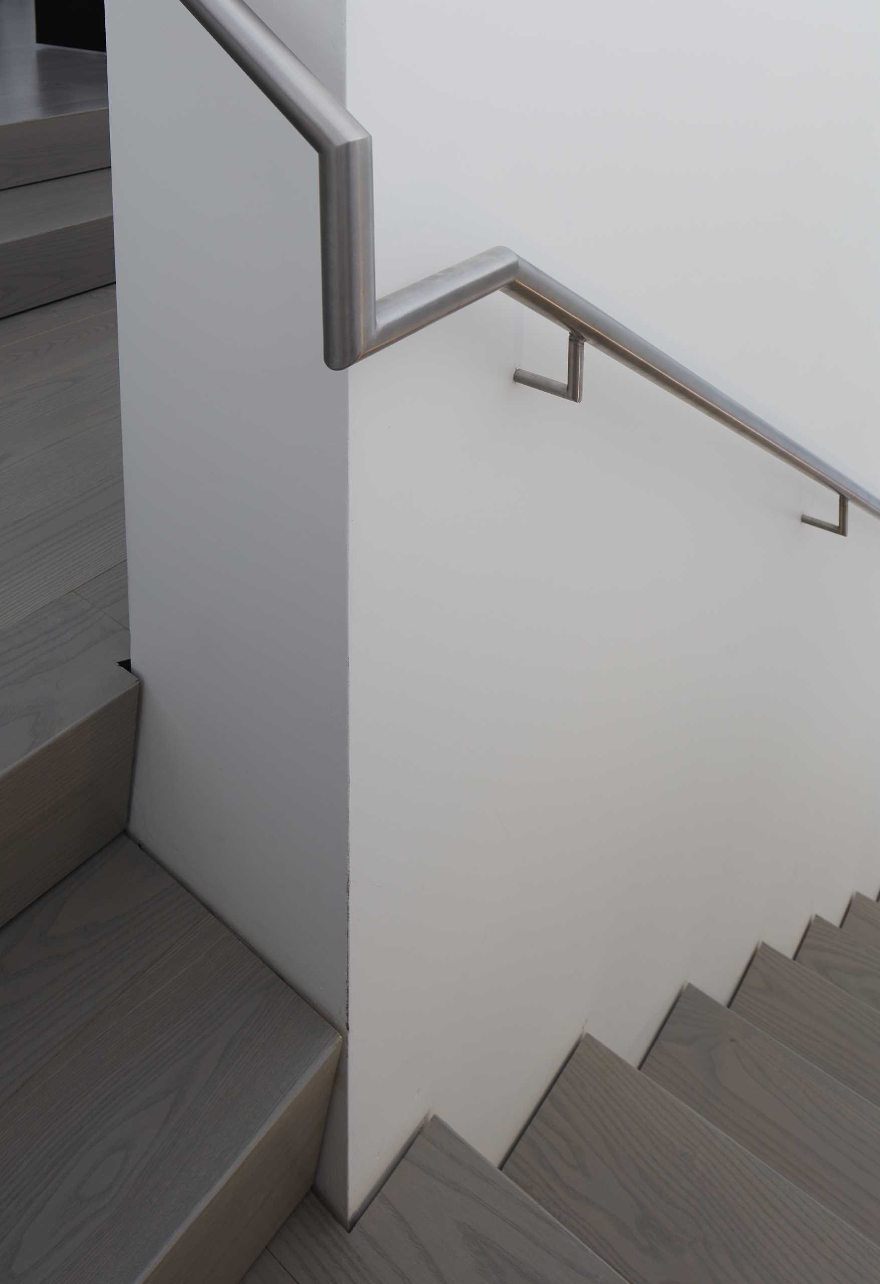 Stairs lead up to a private library area with a slatted wood ceiling that's been painted white.