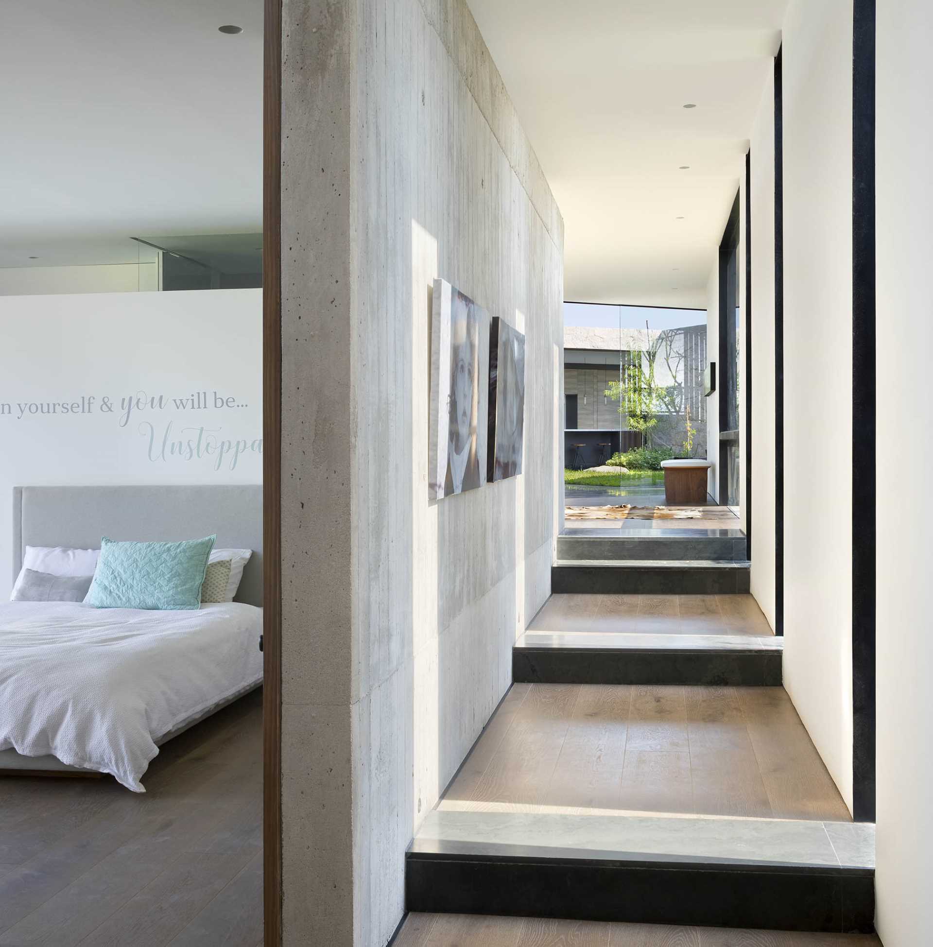 A modern hallway with steps that leads to the bedroom.