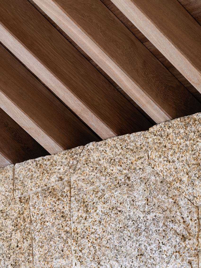 Here's a close-up of where the stone wall meets with the Iroko wood slats featured on the ceiling.