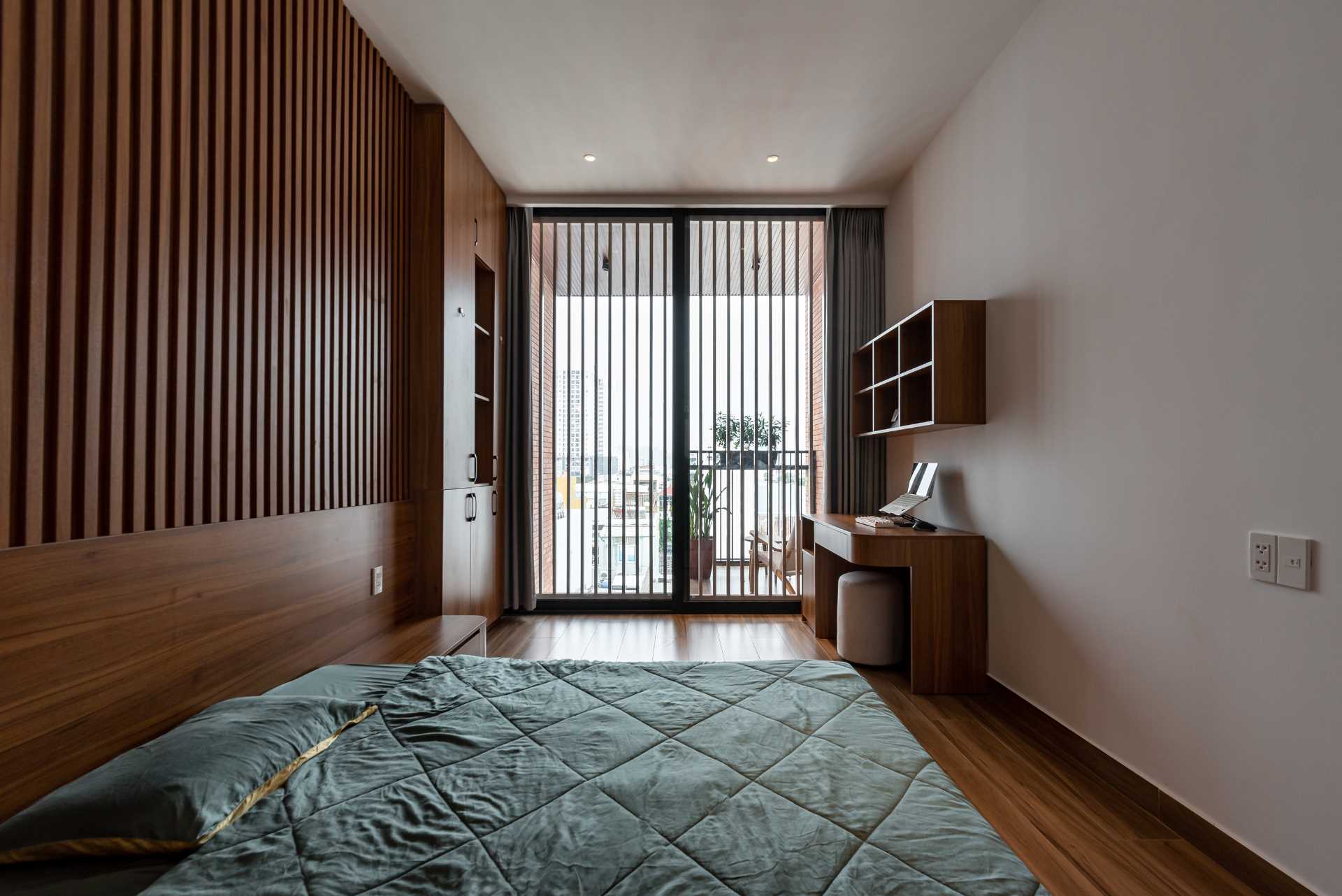 A modern bedroom with a glass-enclosed bathroom and a balcony.