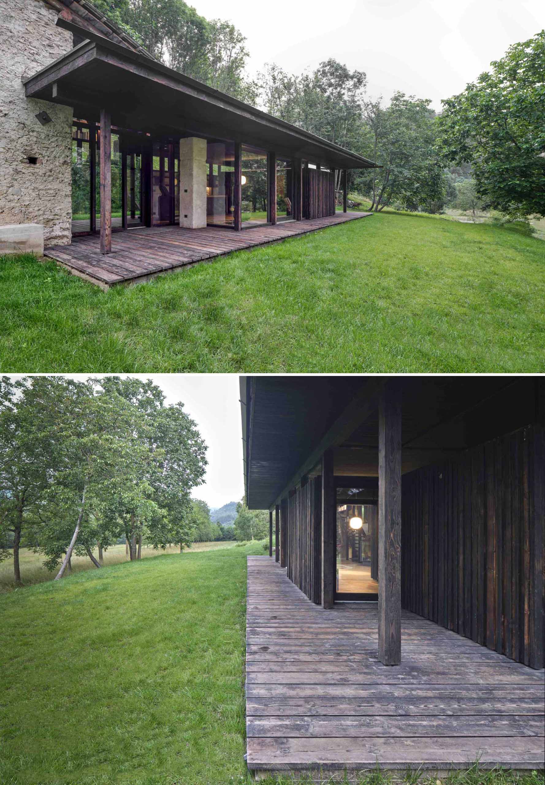 An abandoned stone ruin that was once overgrown with brambles, has been transformed into a small off-grid home with burnt larch wood and large windows.