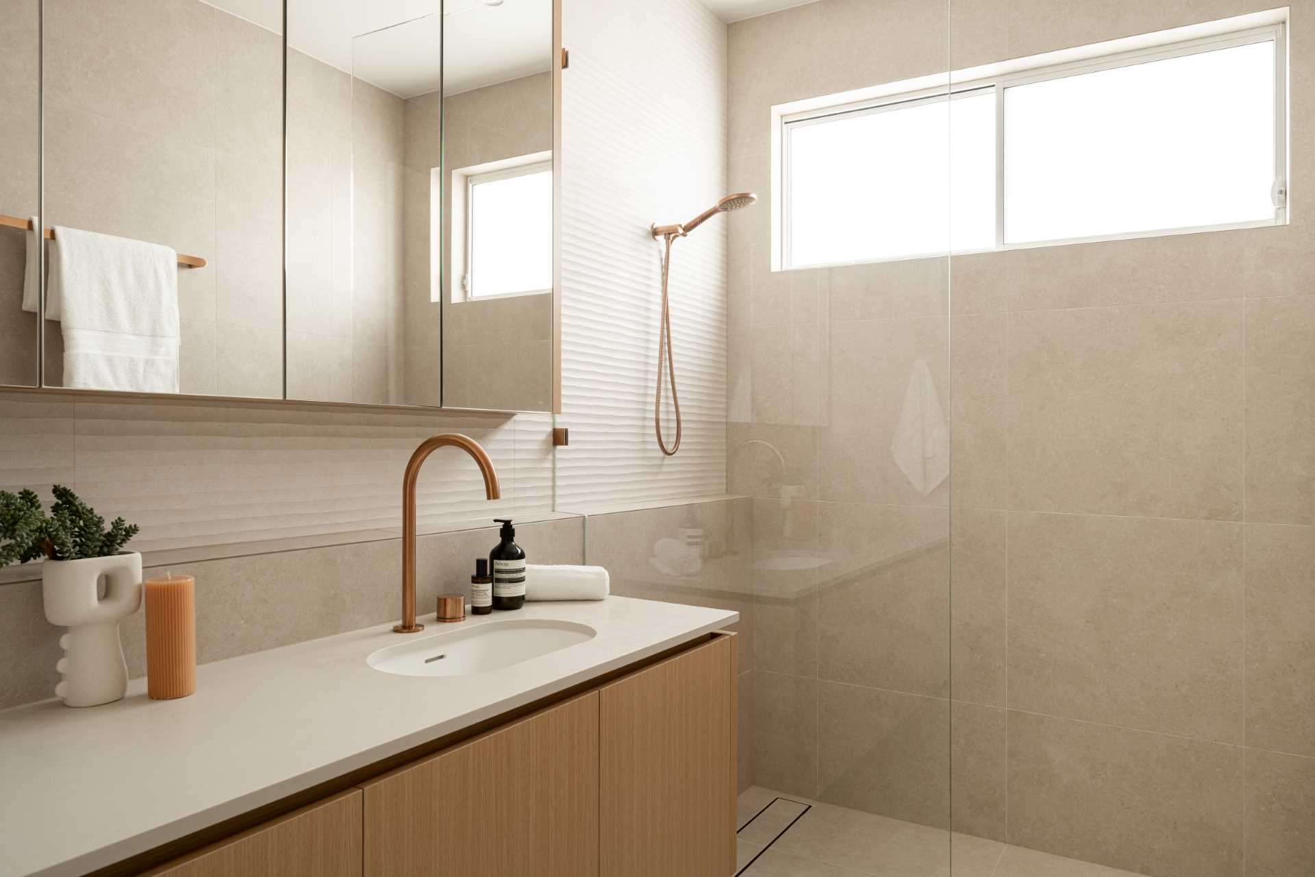 A contemporary bathroom has a s،wer with a shelving ledge.